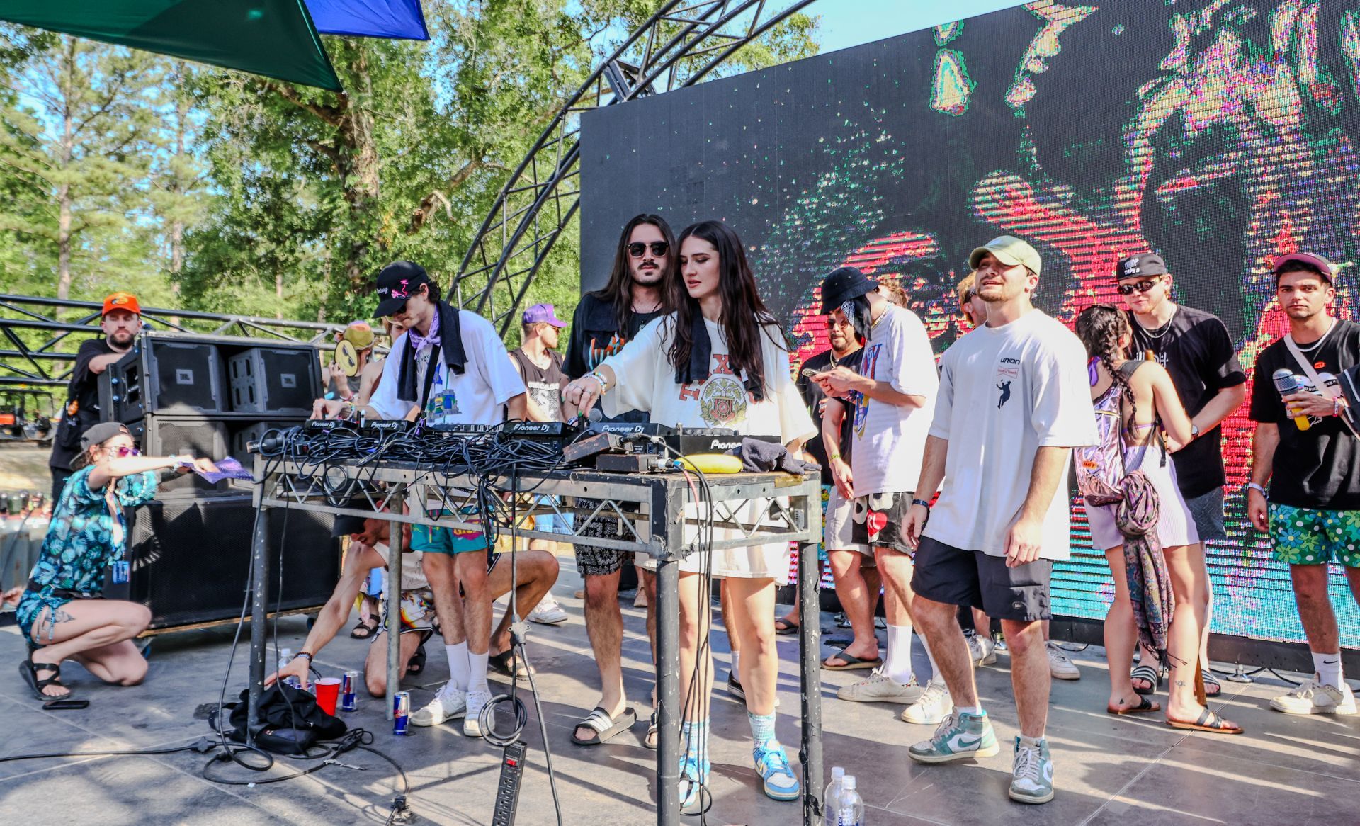 A group of people are standing around a stage at a concert.