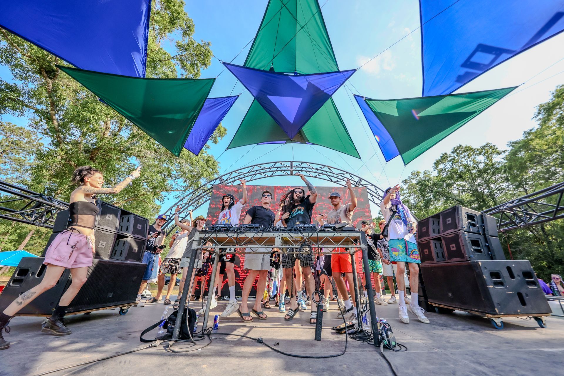A group of people are standing on a stage at a music festival.