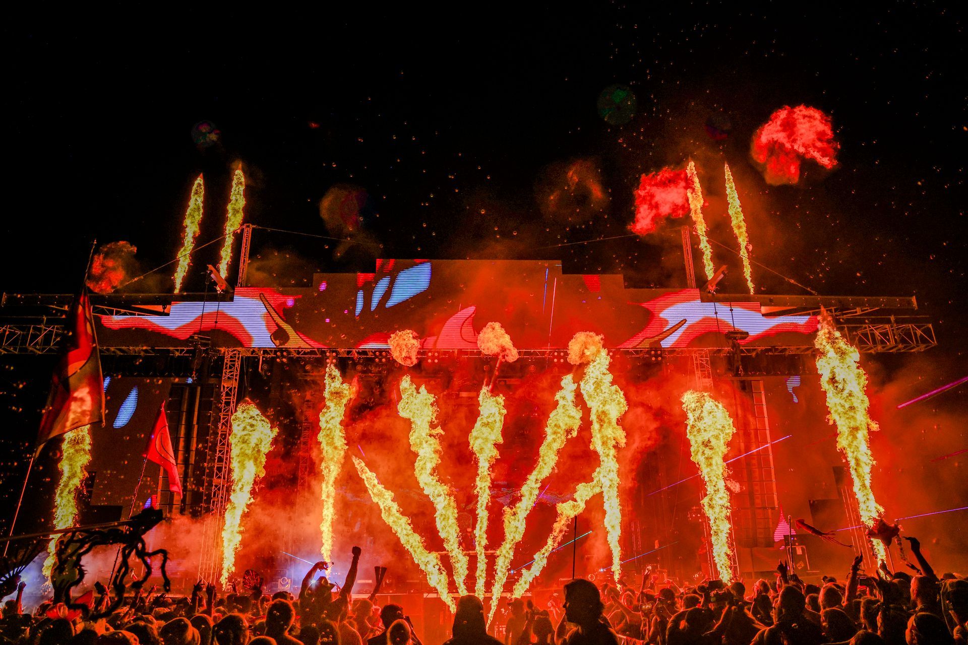 A crowd of people are watching fireworks at a concert.