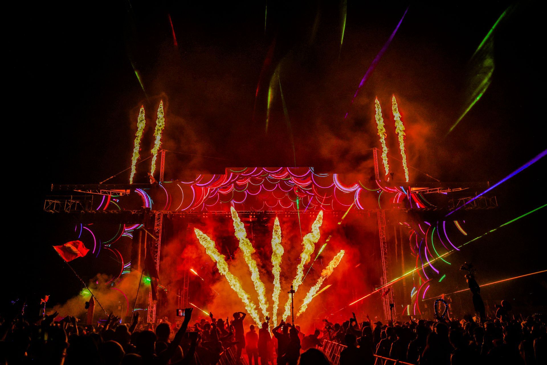 A crowd of people are watching fireworks at a concert.