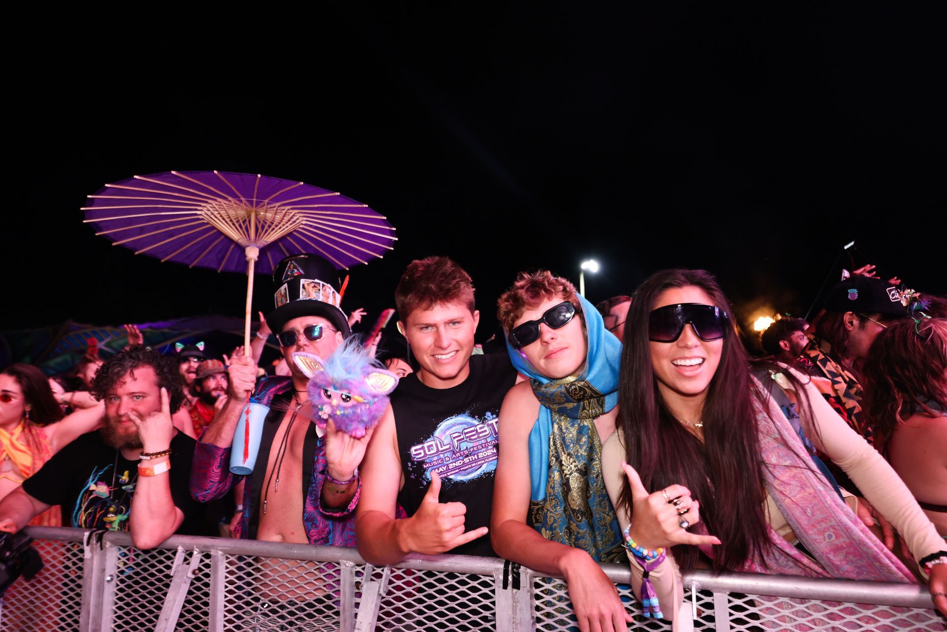 A group of people are posing for a picture at a concert.