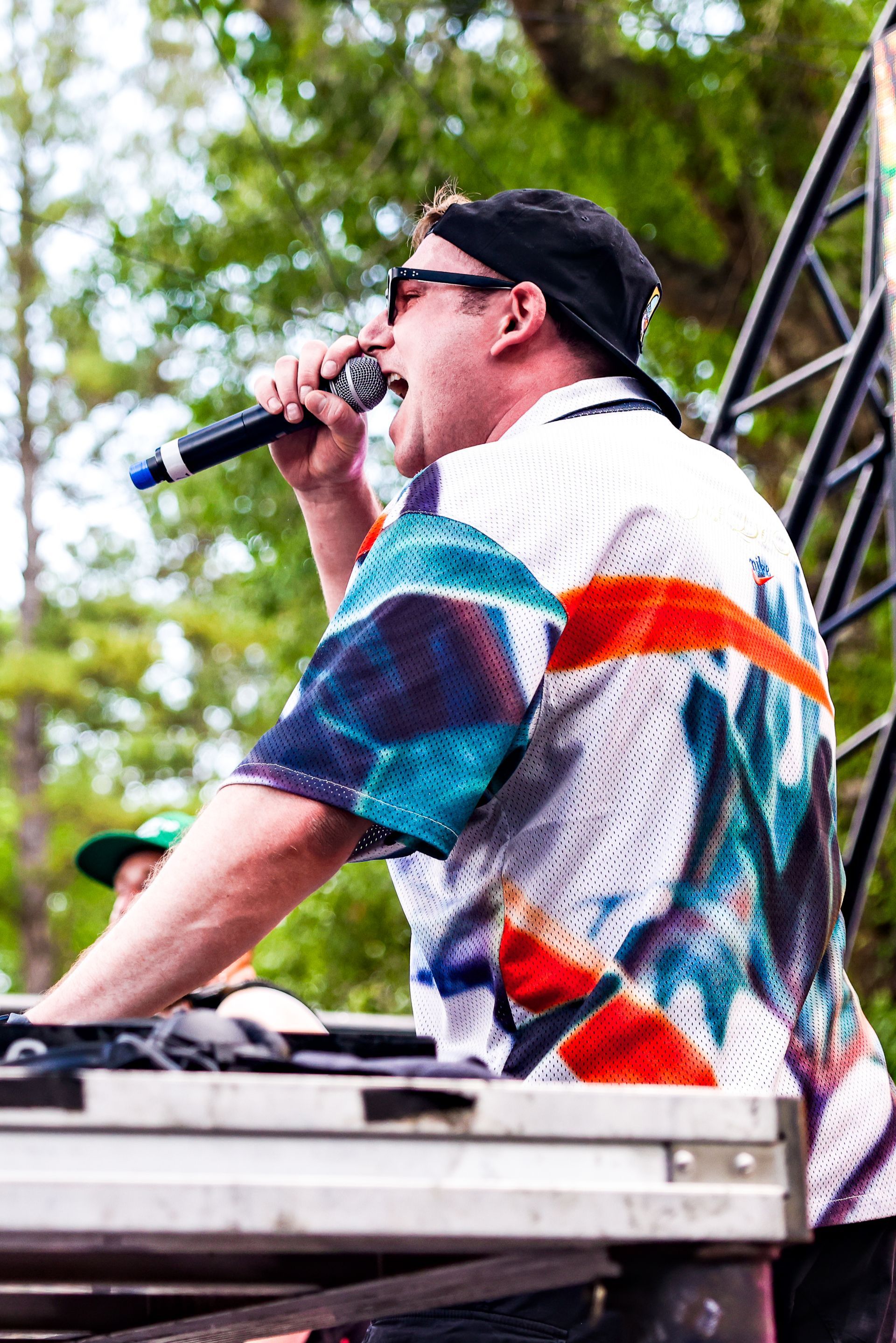 A man is singing into a microphone while sitting at a table.