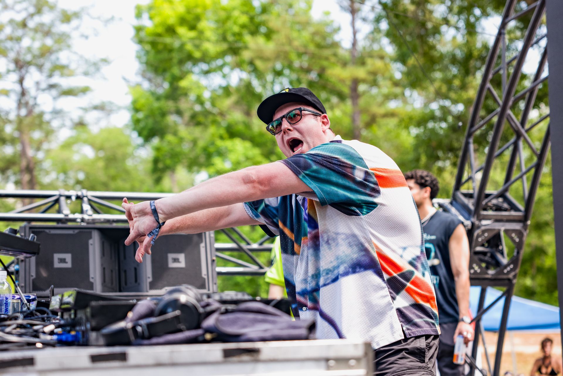A man is standing in front of a stage with his arms outstretched.
