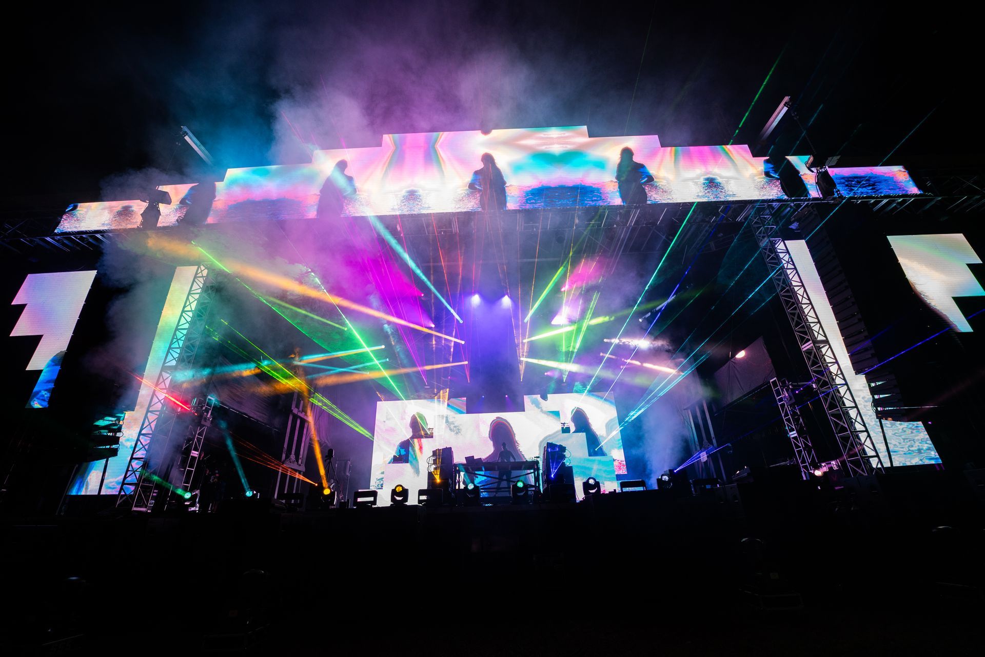 A large stage with a lot of lights and smoke coming out of it.