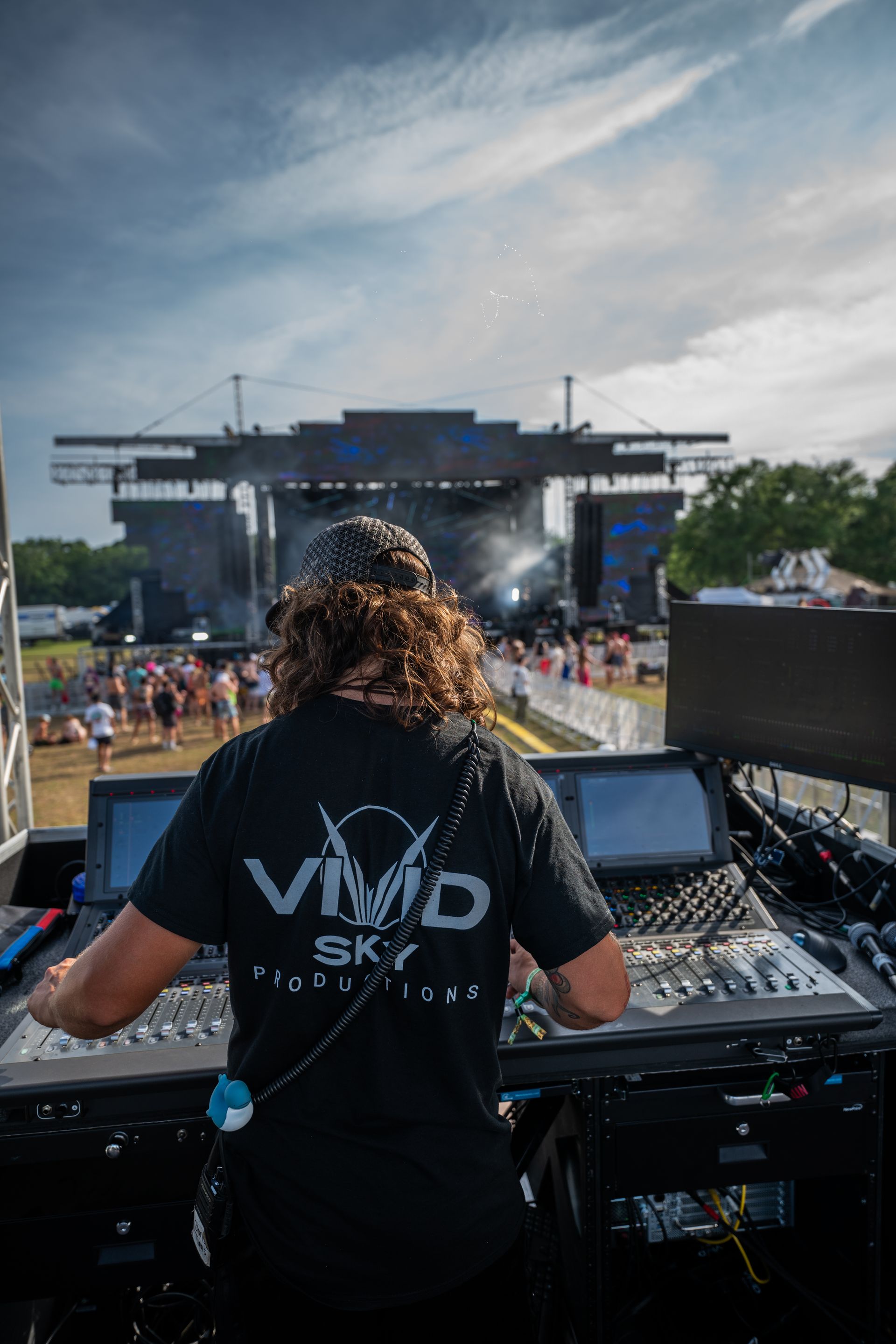 A man is standing in front of a stage at a concert.