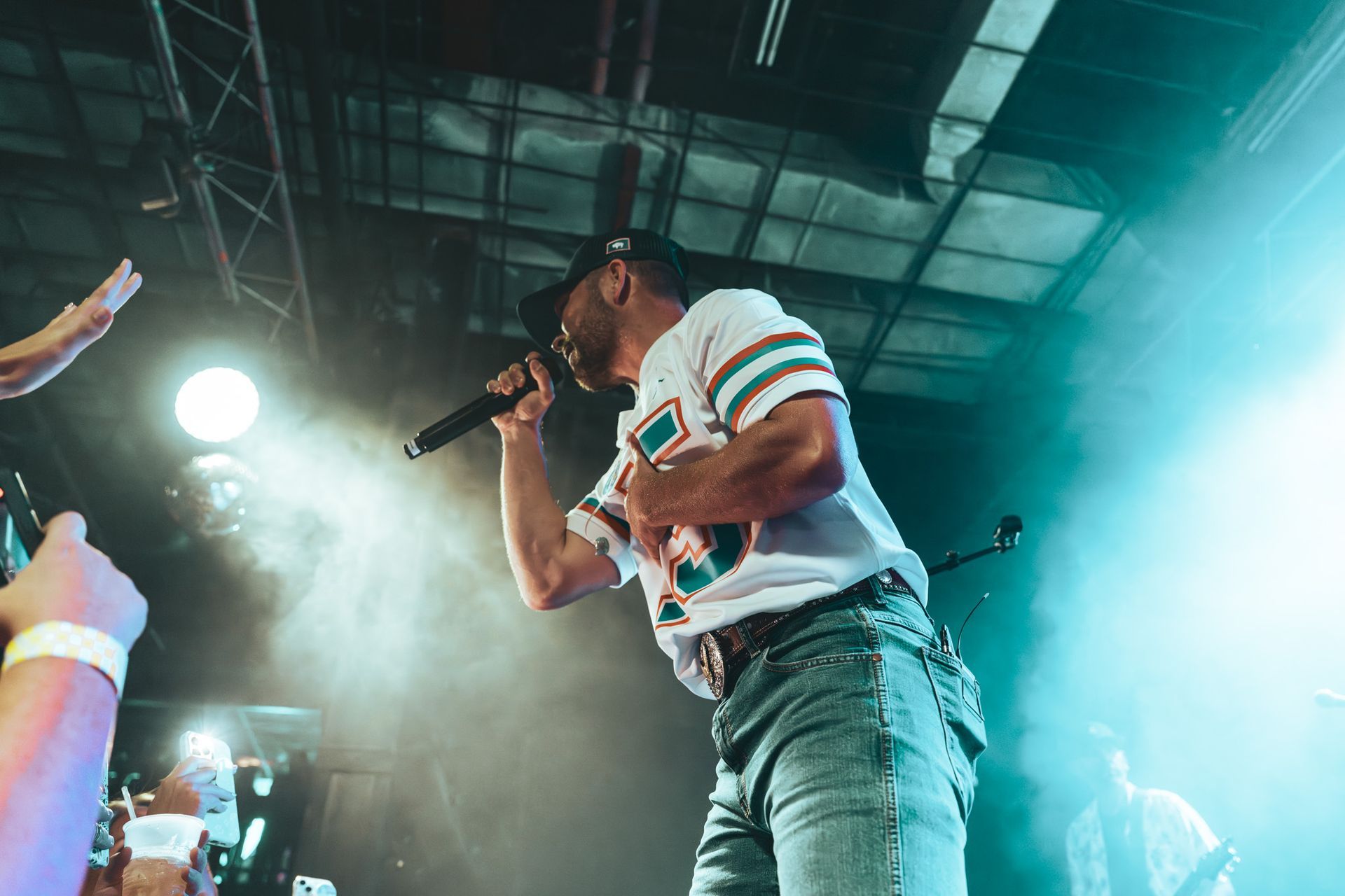 A man is singing into a microphone on a stage.