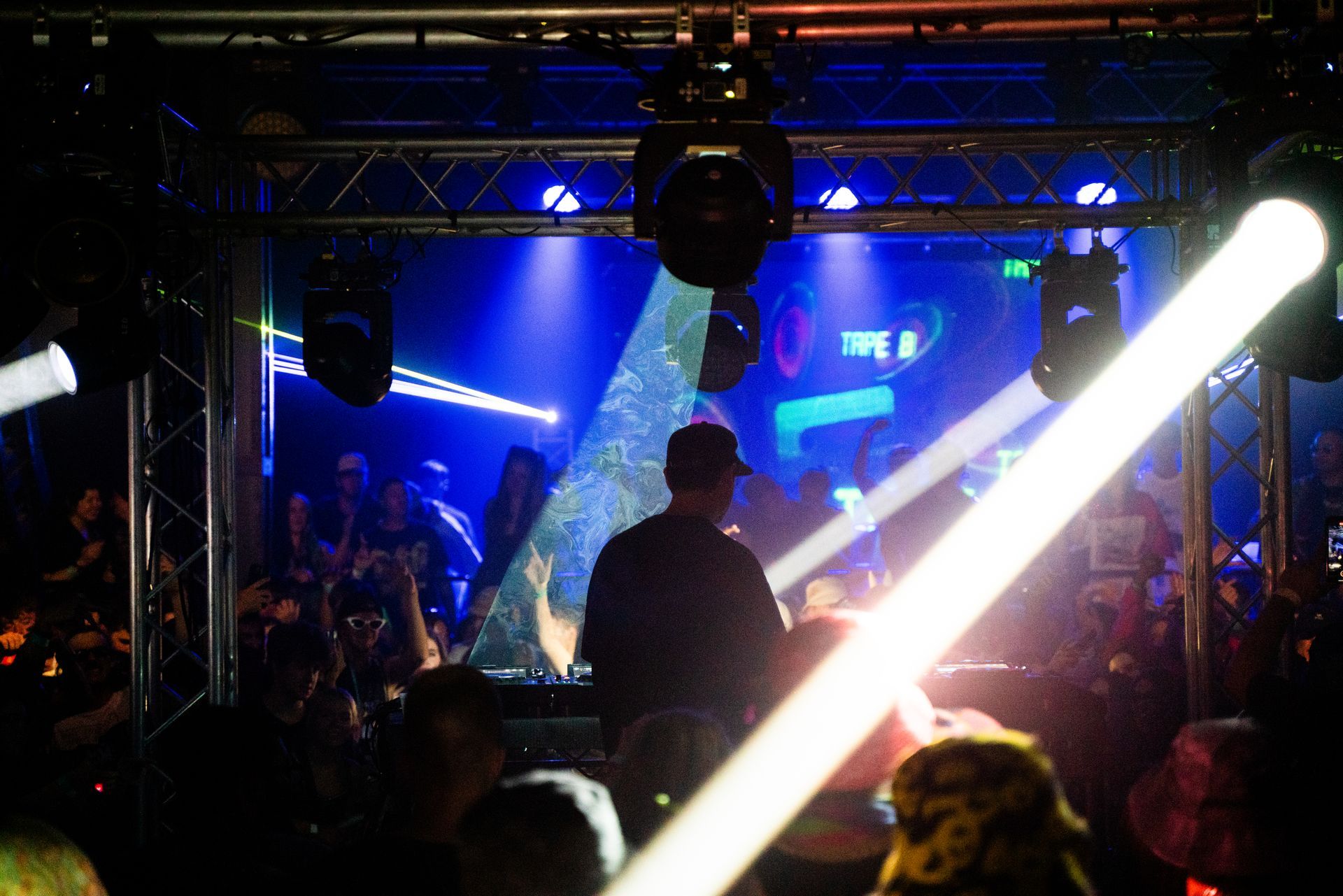 A man is playing a dj set in a dark room