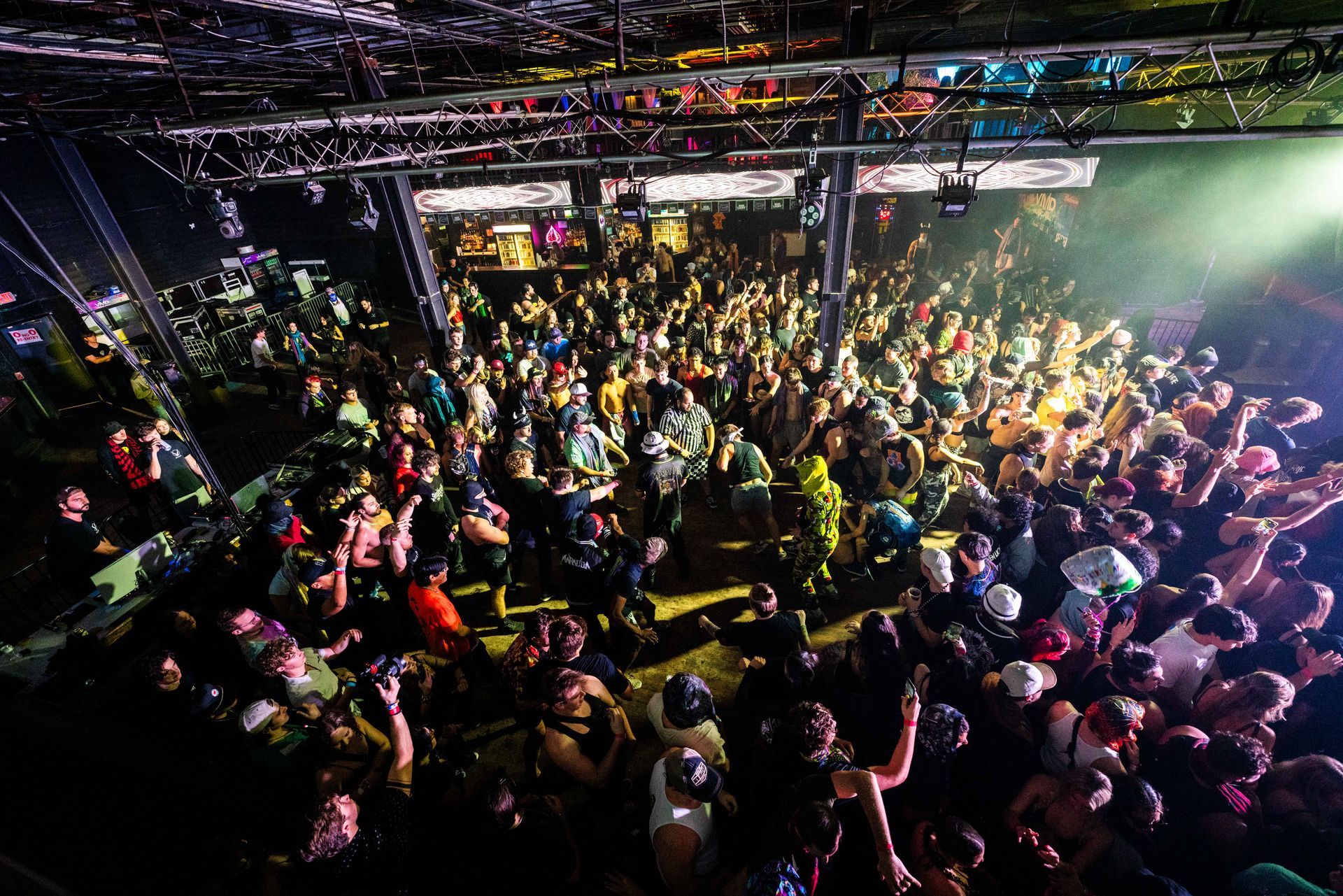 A large crowd of people are dancing in a club.