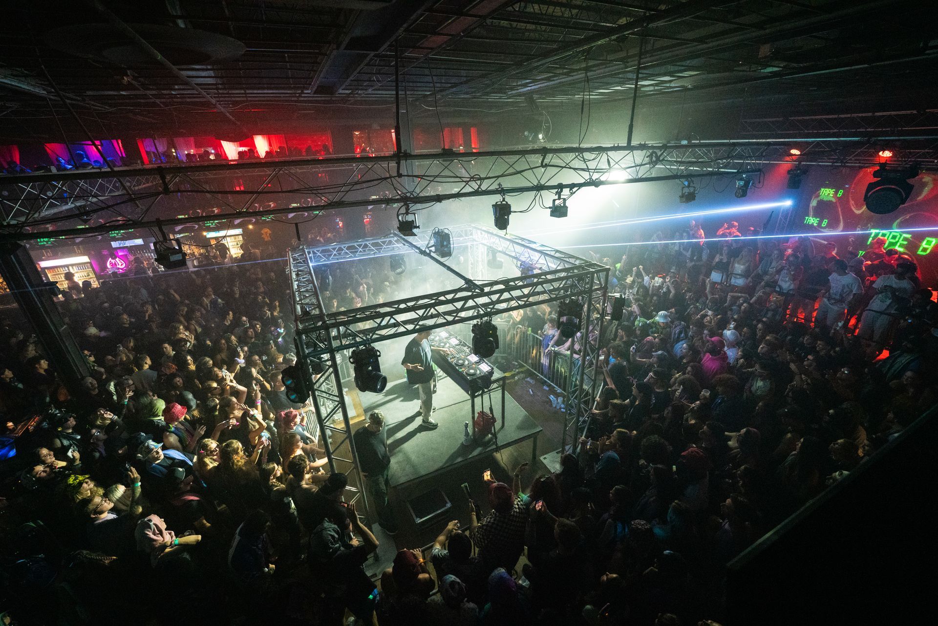 A large crowd of people are watching a band on stage at a concert.