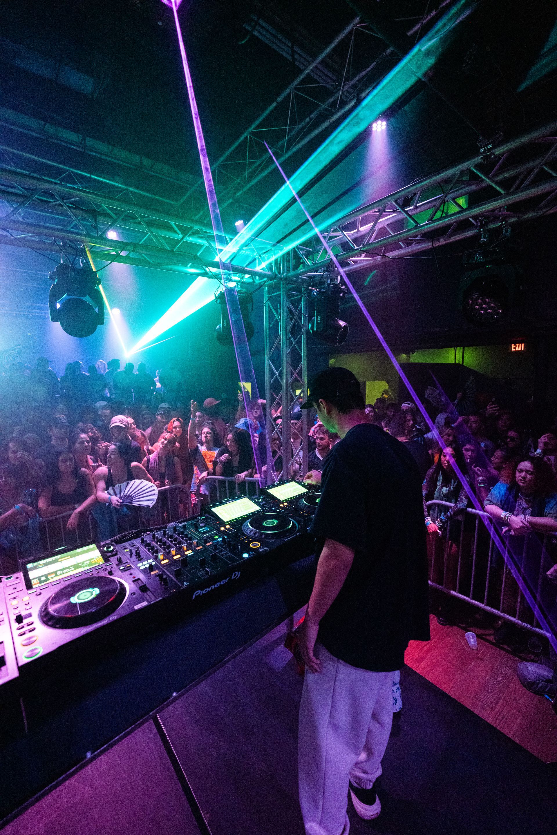 A dj is playing music in front of a crowd at a concert.