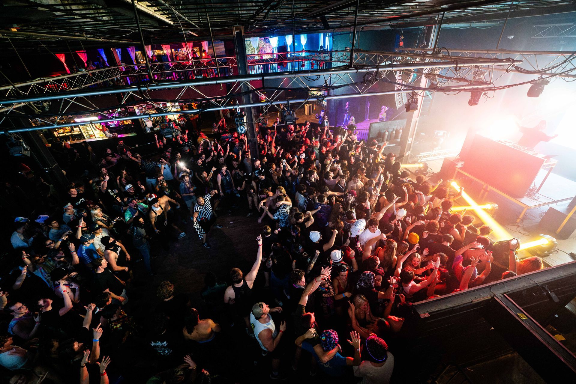 A crowd of people at a concert with their hands in the air