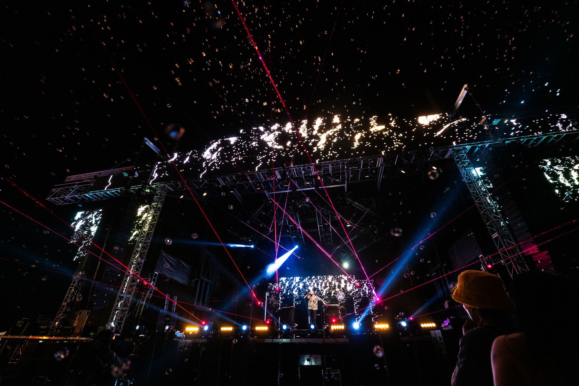 A group of people are standing in front of a stage at a concert.