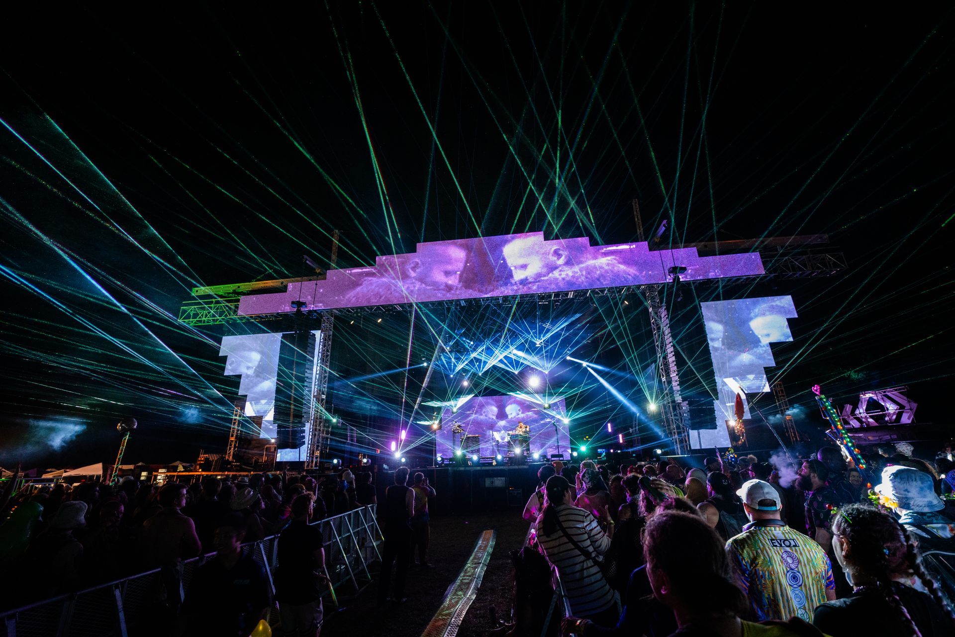 A crowd of people are watching a concert at night.