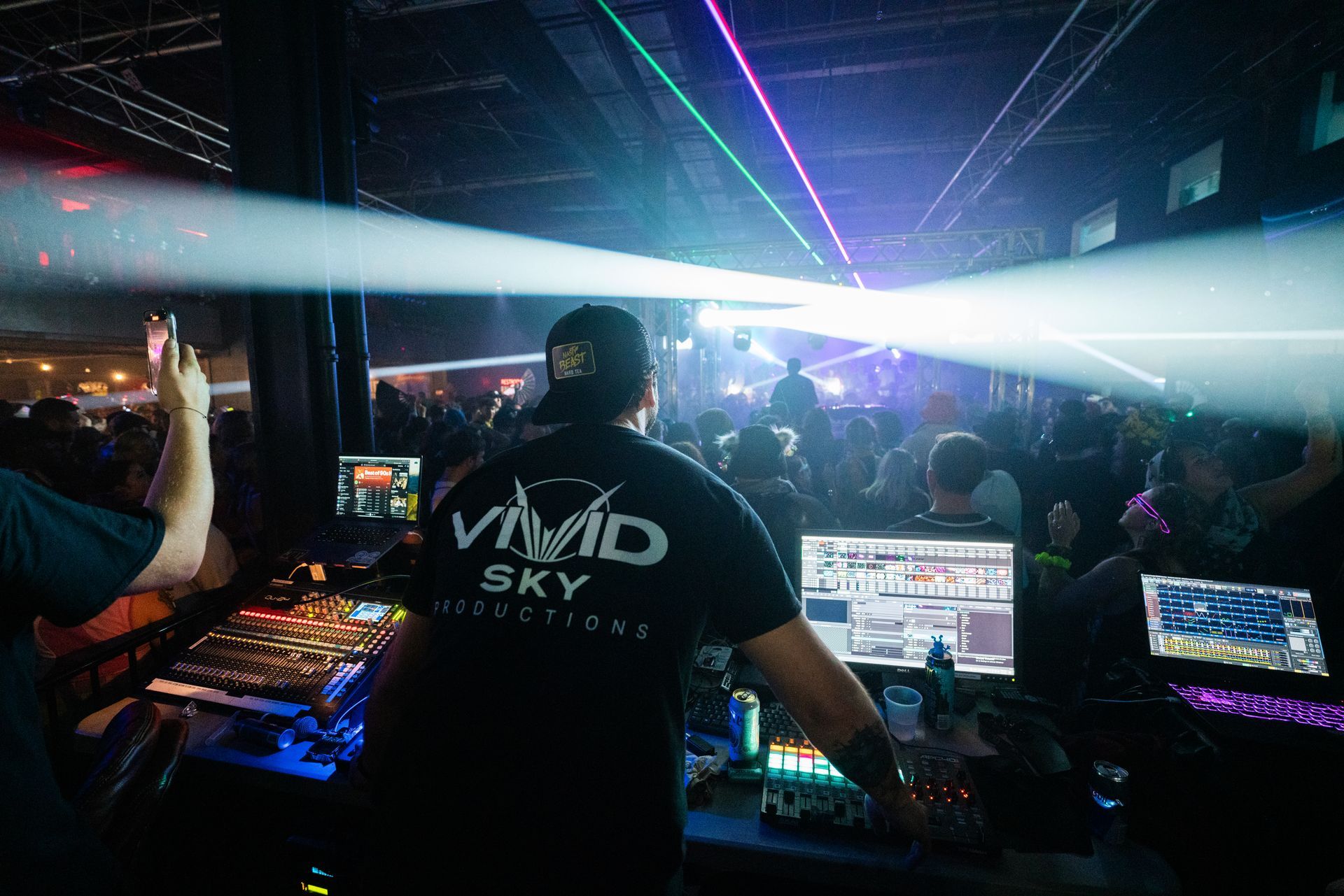 A dj is playing music in front of a crowd at a party.