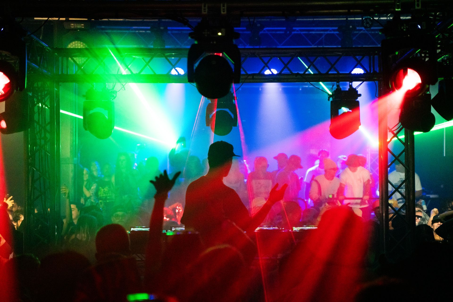 A group of people are standing in front of a stage at a concert.