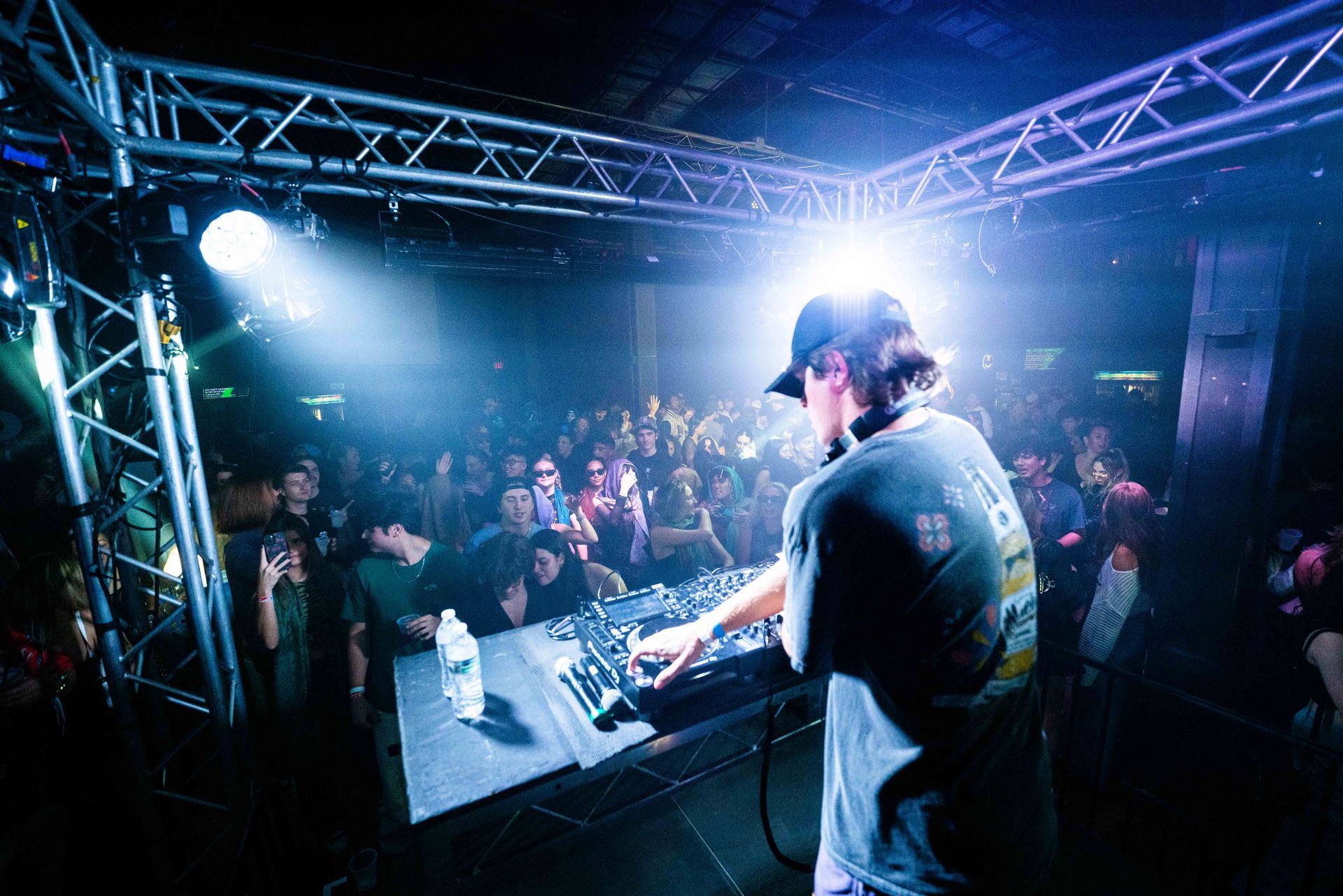 A man is playing a dj set in front of a crowd at a concert.