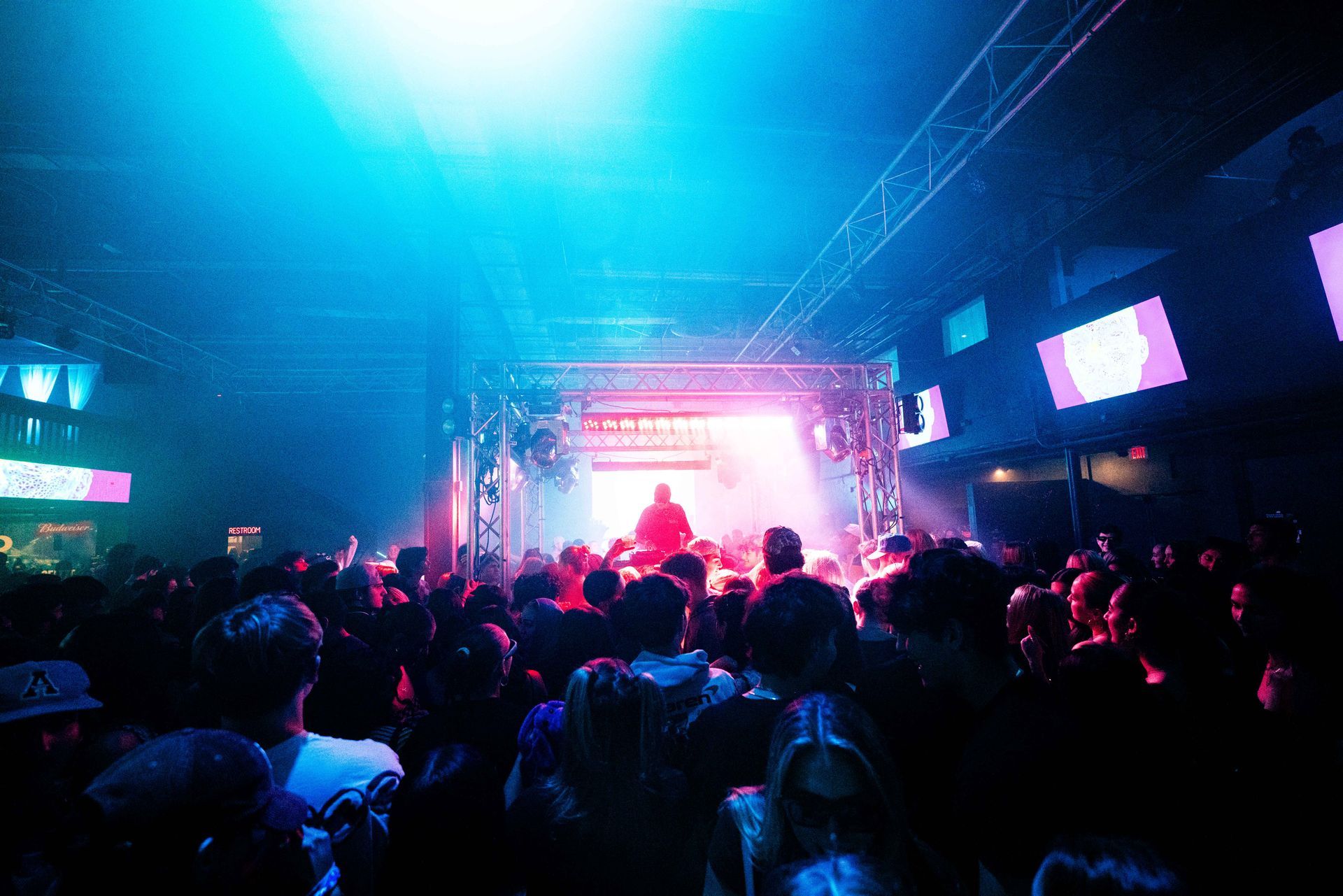 A crowd of people are standing in front of a stage at a concert.
