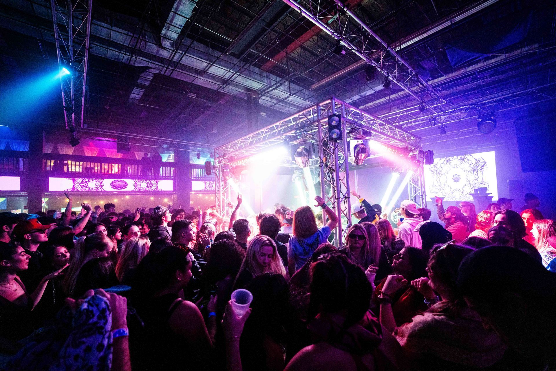 A large crowd of people are dancing in a club.