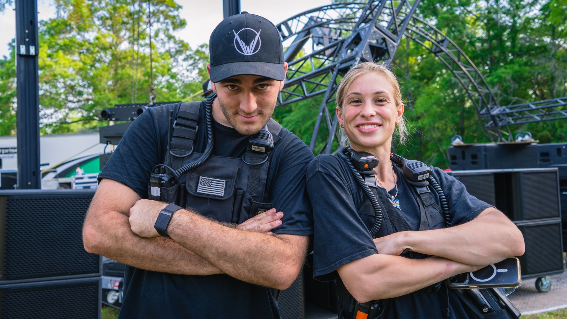 A man and a woman are standing next to each other with their arms crossed.