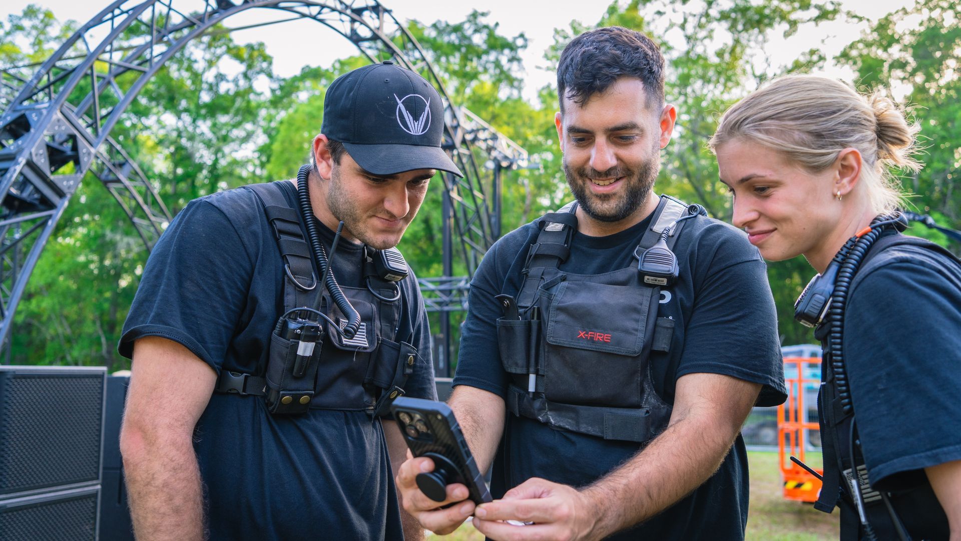 A group of people are standing next to each other looking at a tablet.