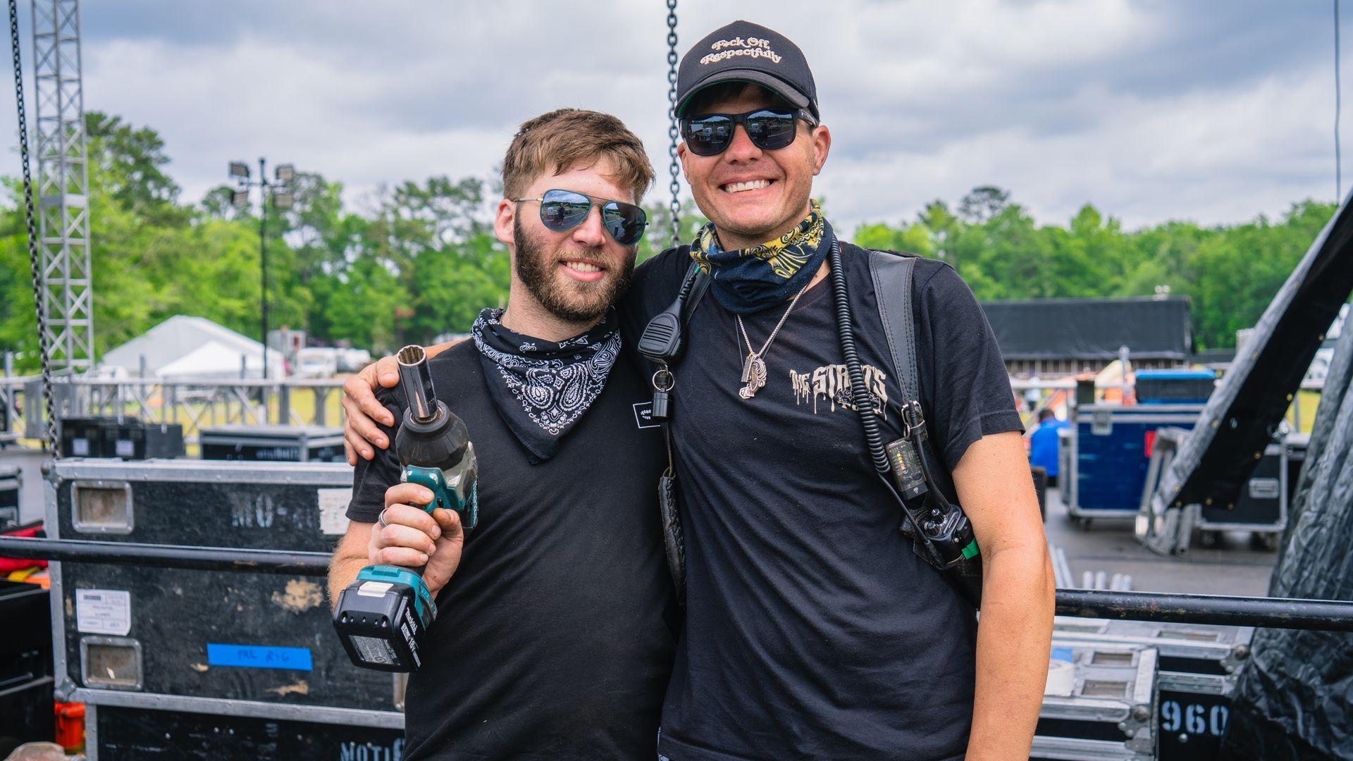 Two men are posing for a picture in front of a truck.