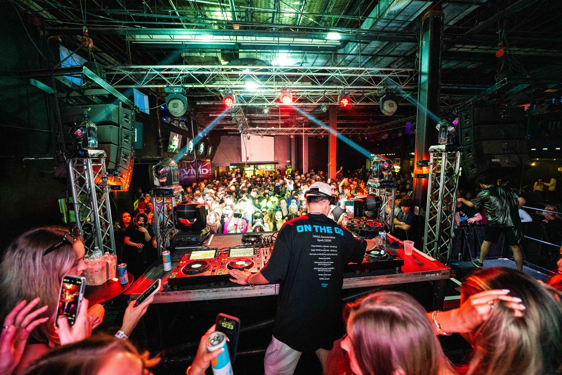 A dj is playing music in front of a crowd at a party.
