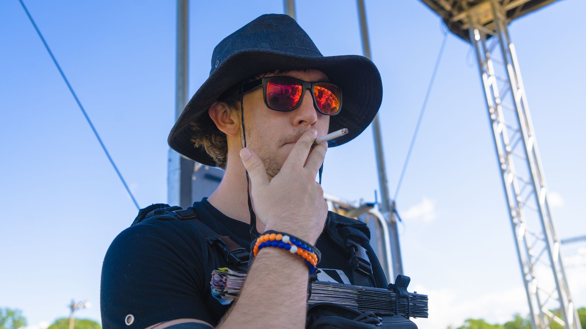 Man smoking with a black hat on.