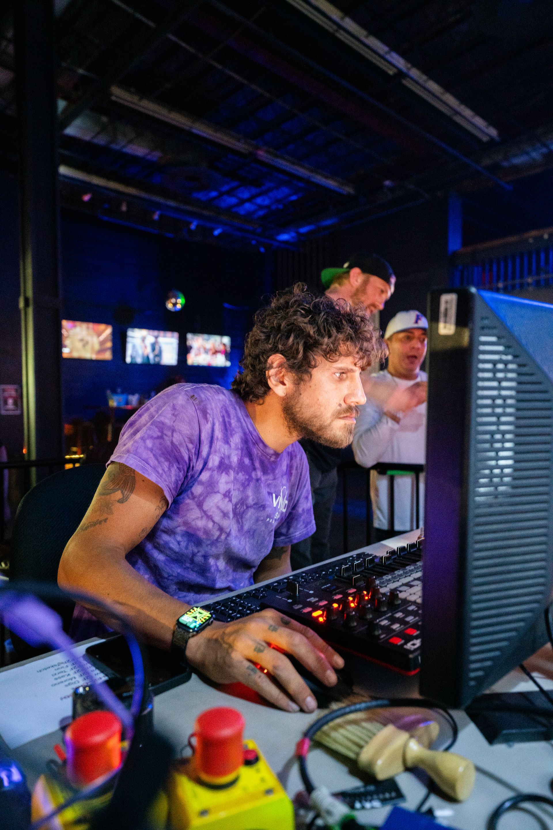 A man is sitting in front of a computer in a dark room.