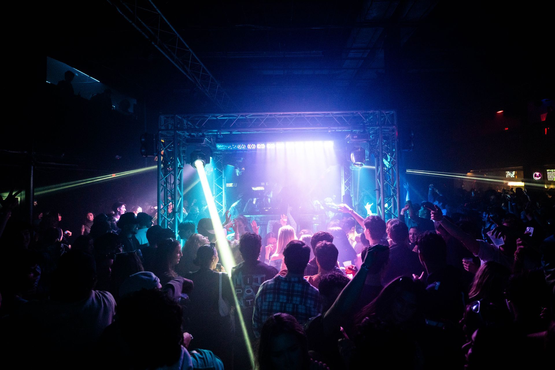 A crowd of people are standing in front of a stage at a concert.