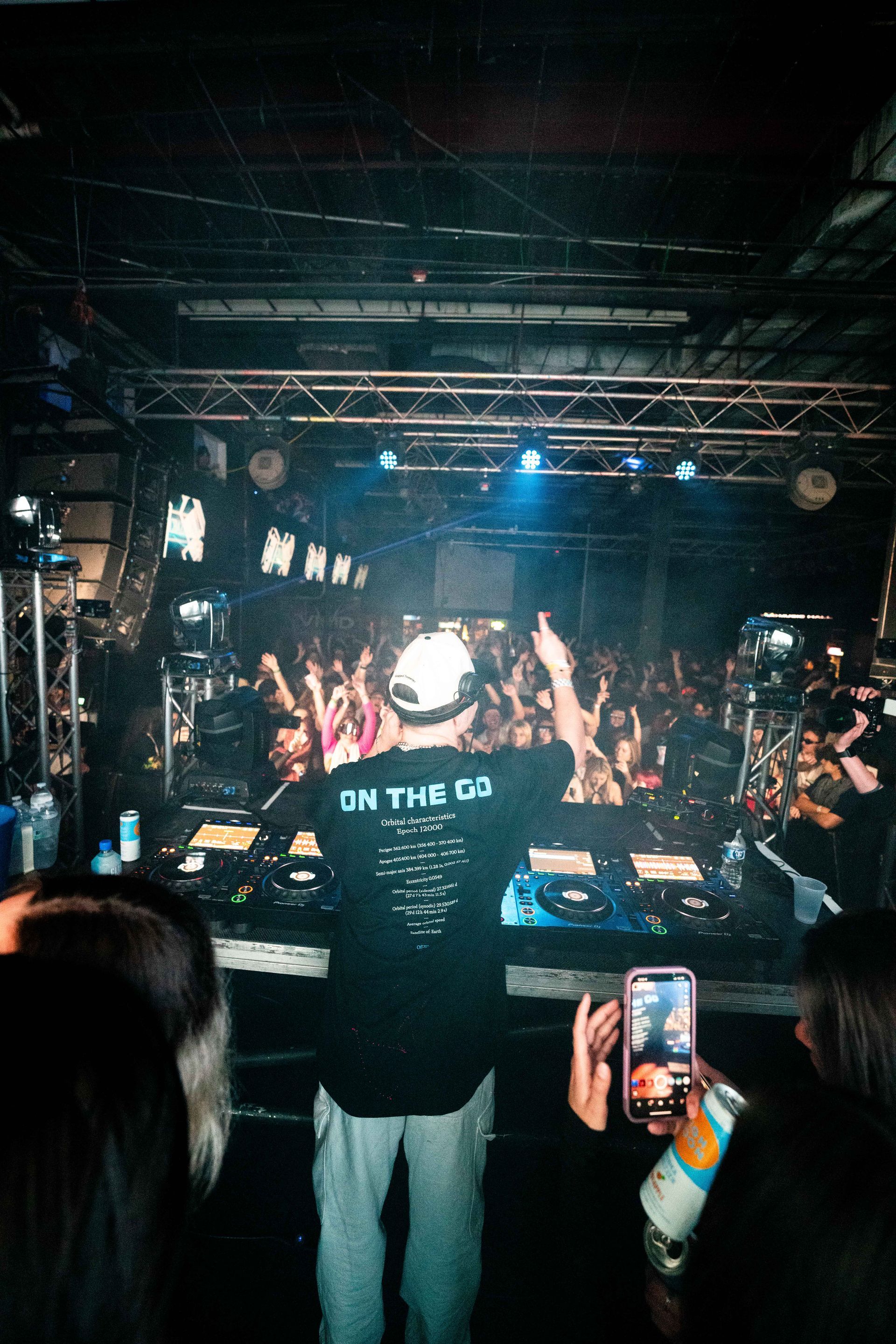 A dj is playing music in front of a crowd at a concert.
