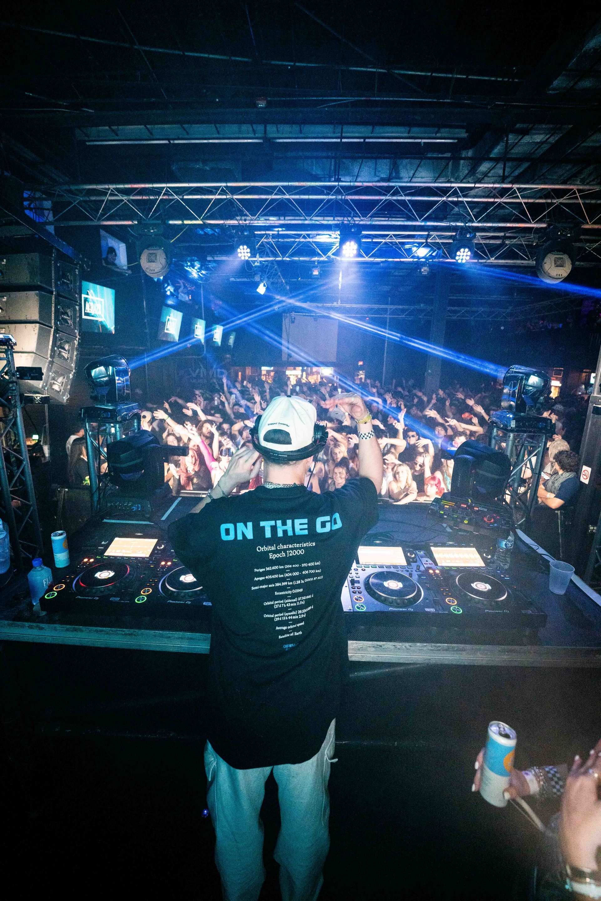 A dj is standing in front of a crowd at a concert.