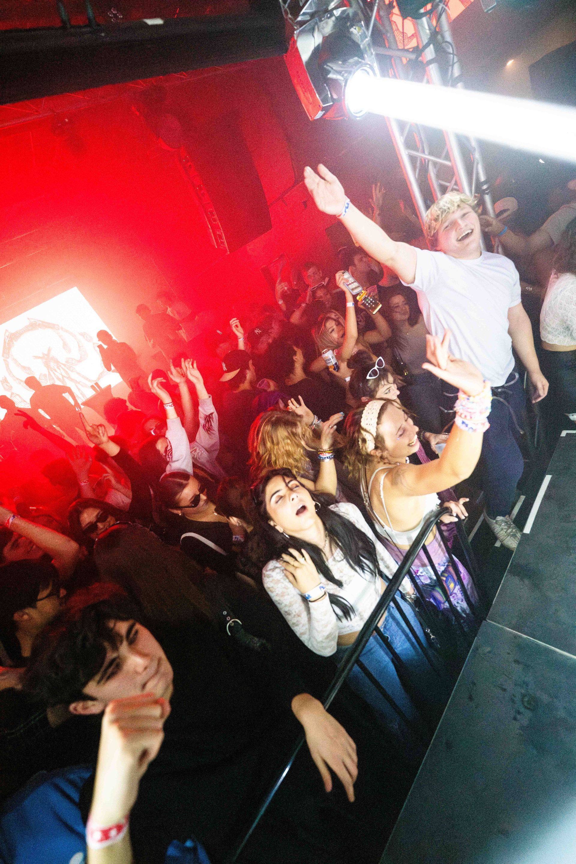 A group of people are standing in a crowd at a concert.