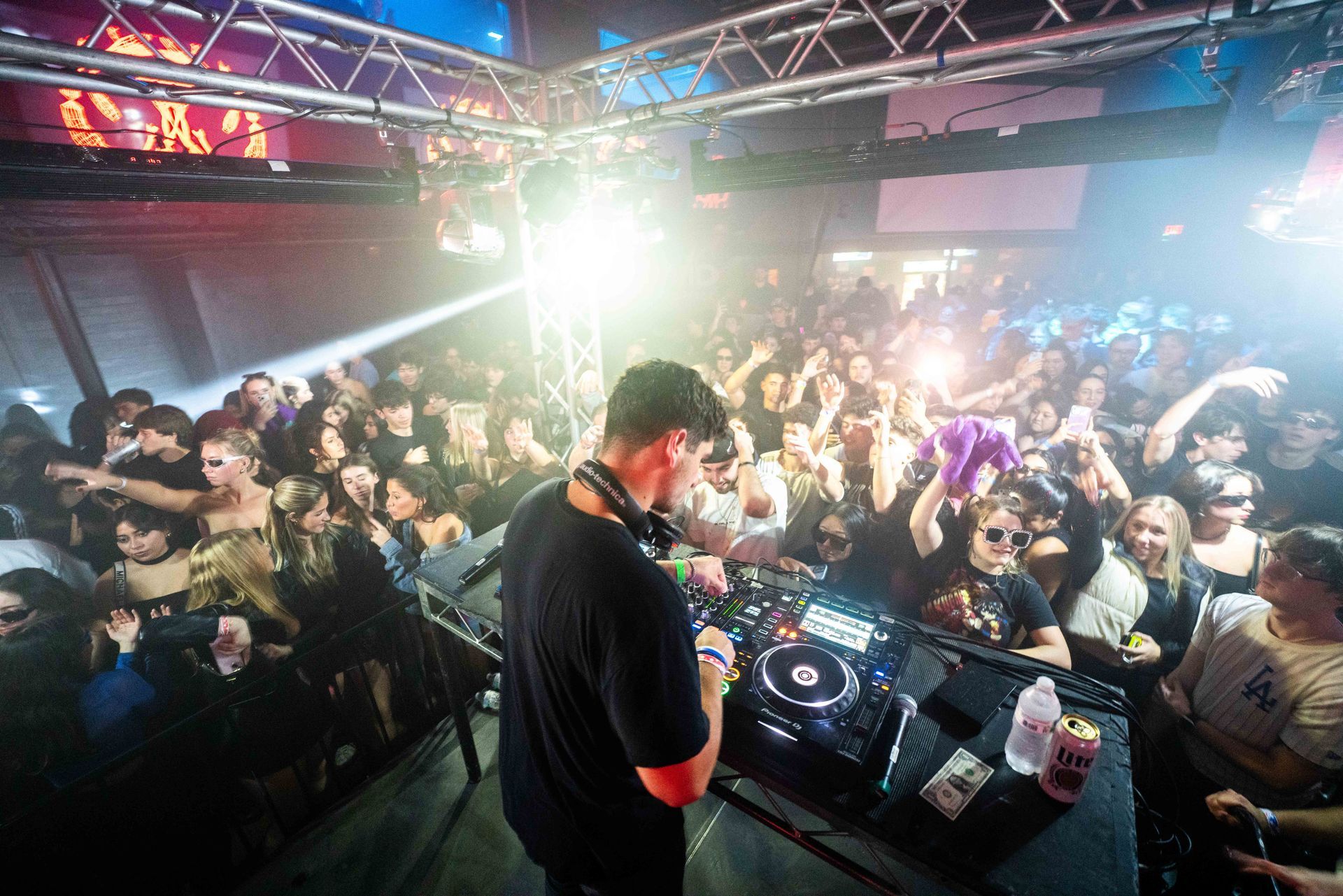A dj is playing music in front of a crowd at a party.