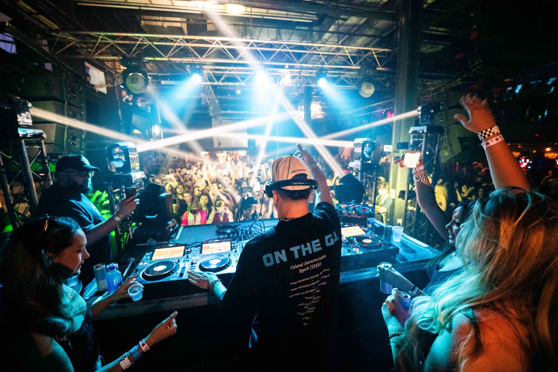 A dj is playing music in front of a crowd at a party.