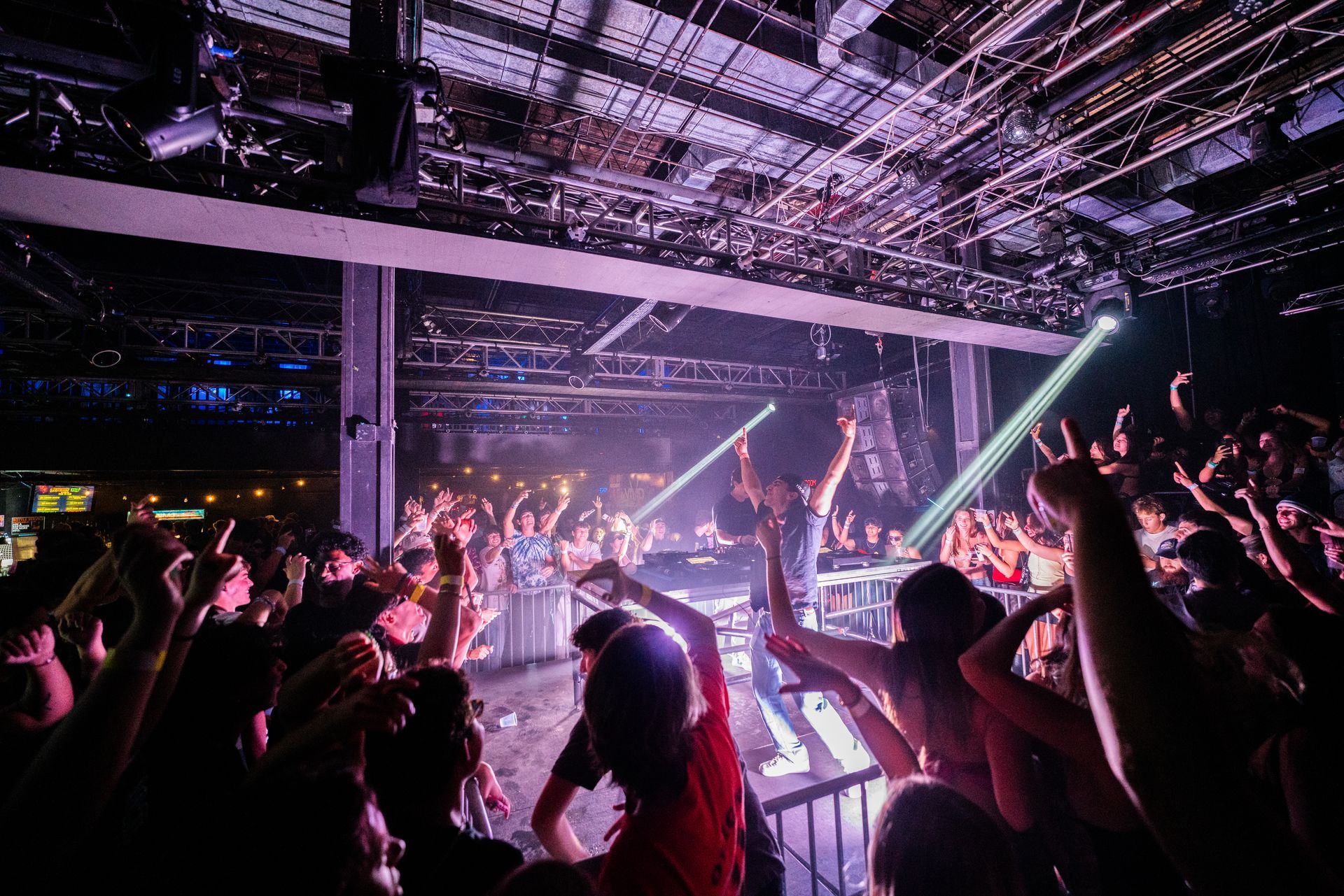 A crowd of people are standing in front of a stage at a concert.