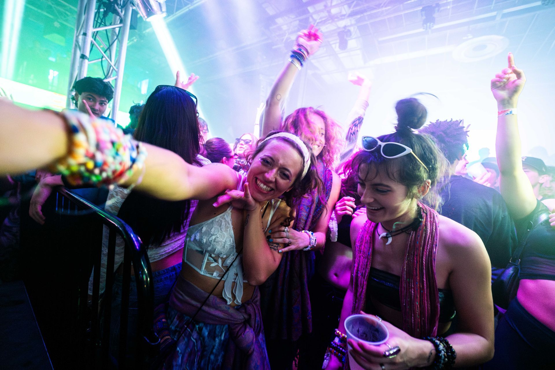 A group of people are dancing at a party in a club.