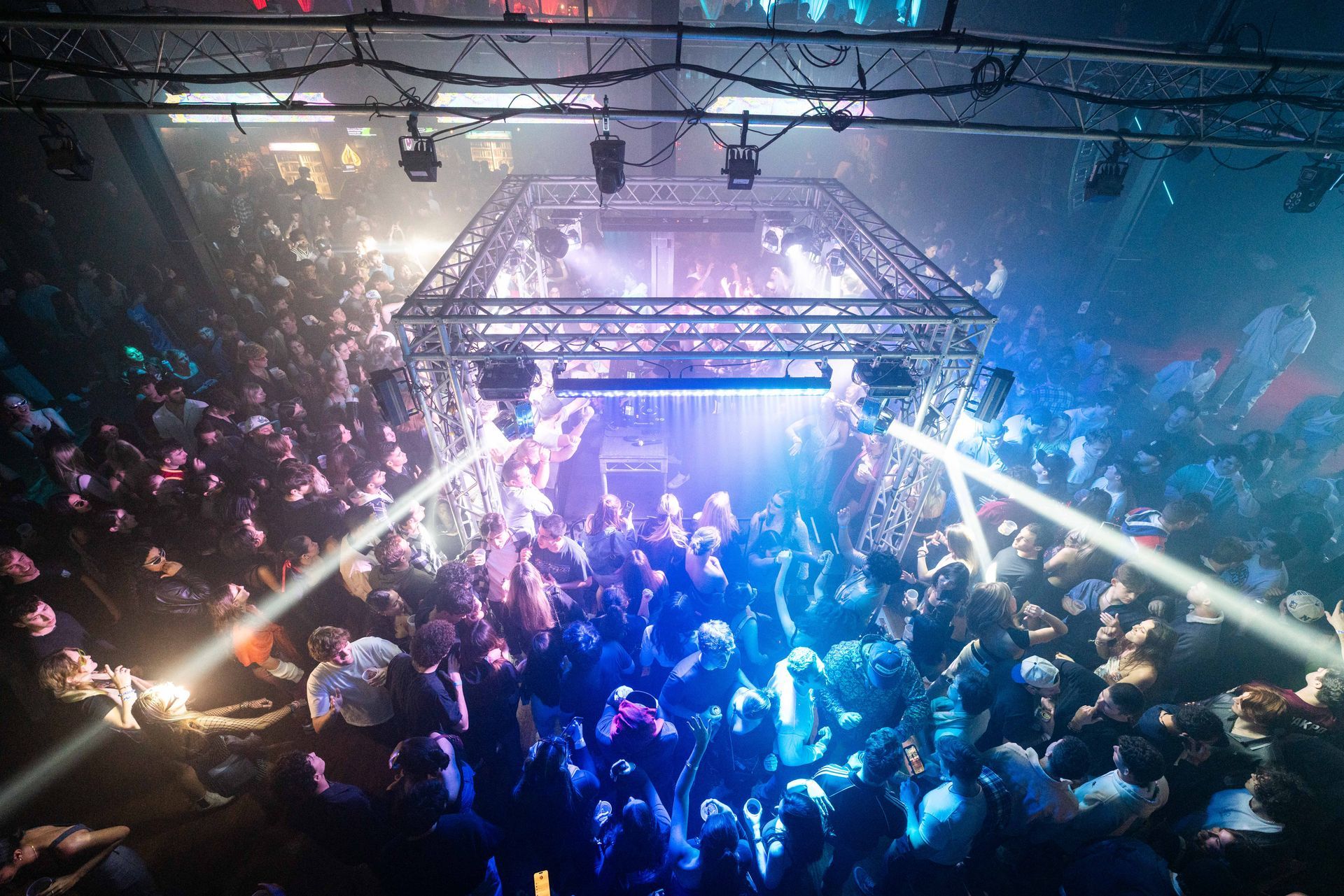 A large crowd of people are dancing in a club.