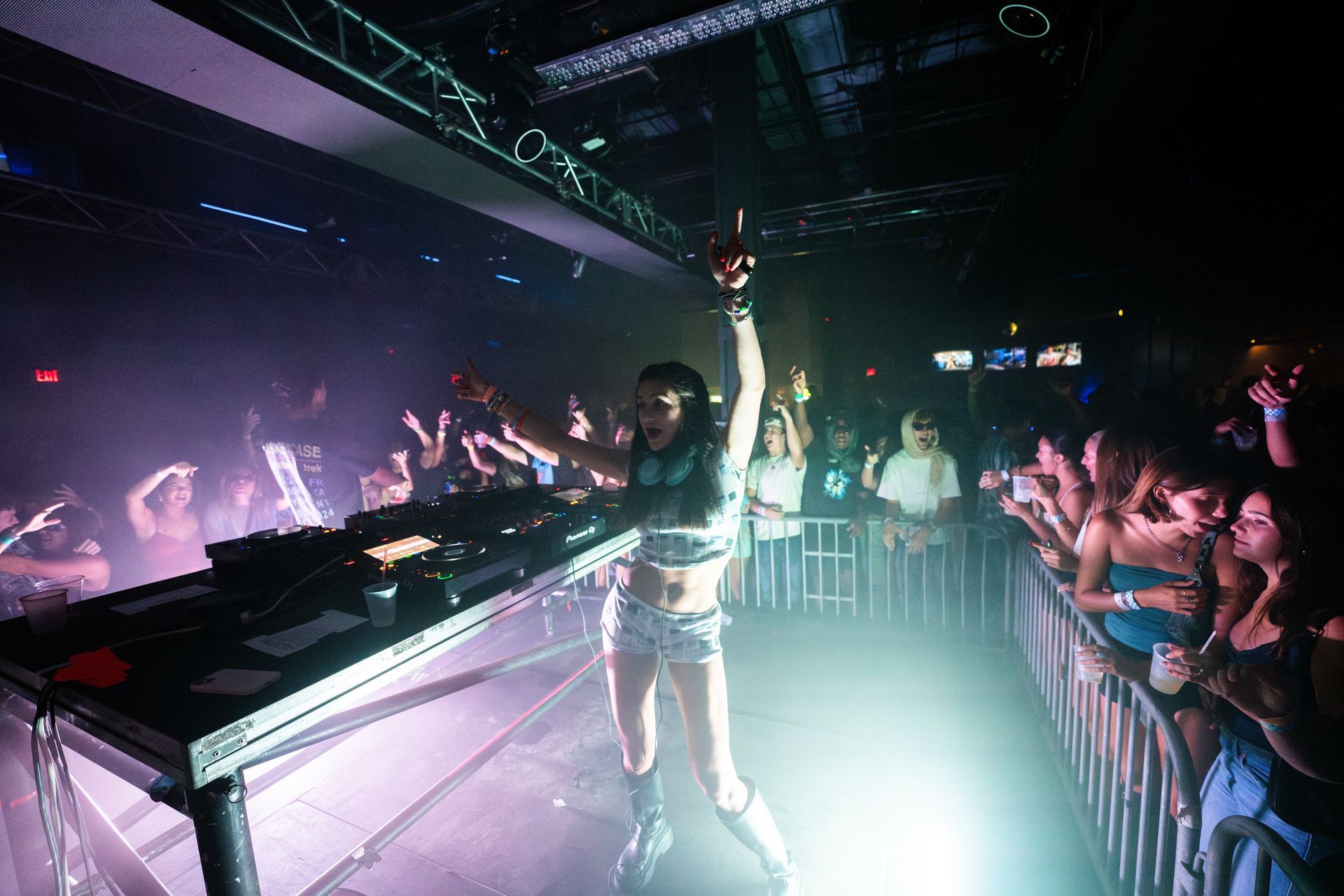 A woman is standing on a stage in front of a crowd at a concert.