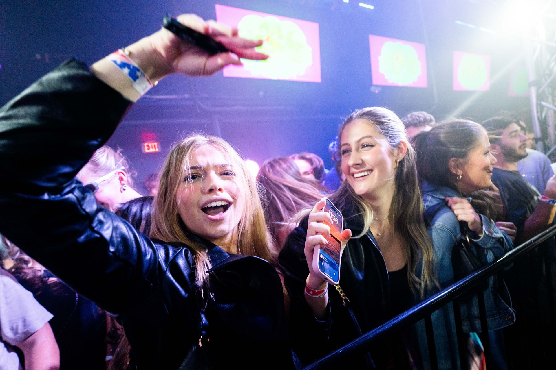 A group of people are standing in a crowd at a concert.