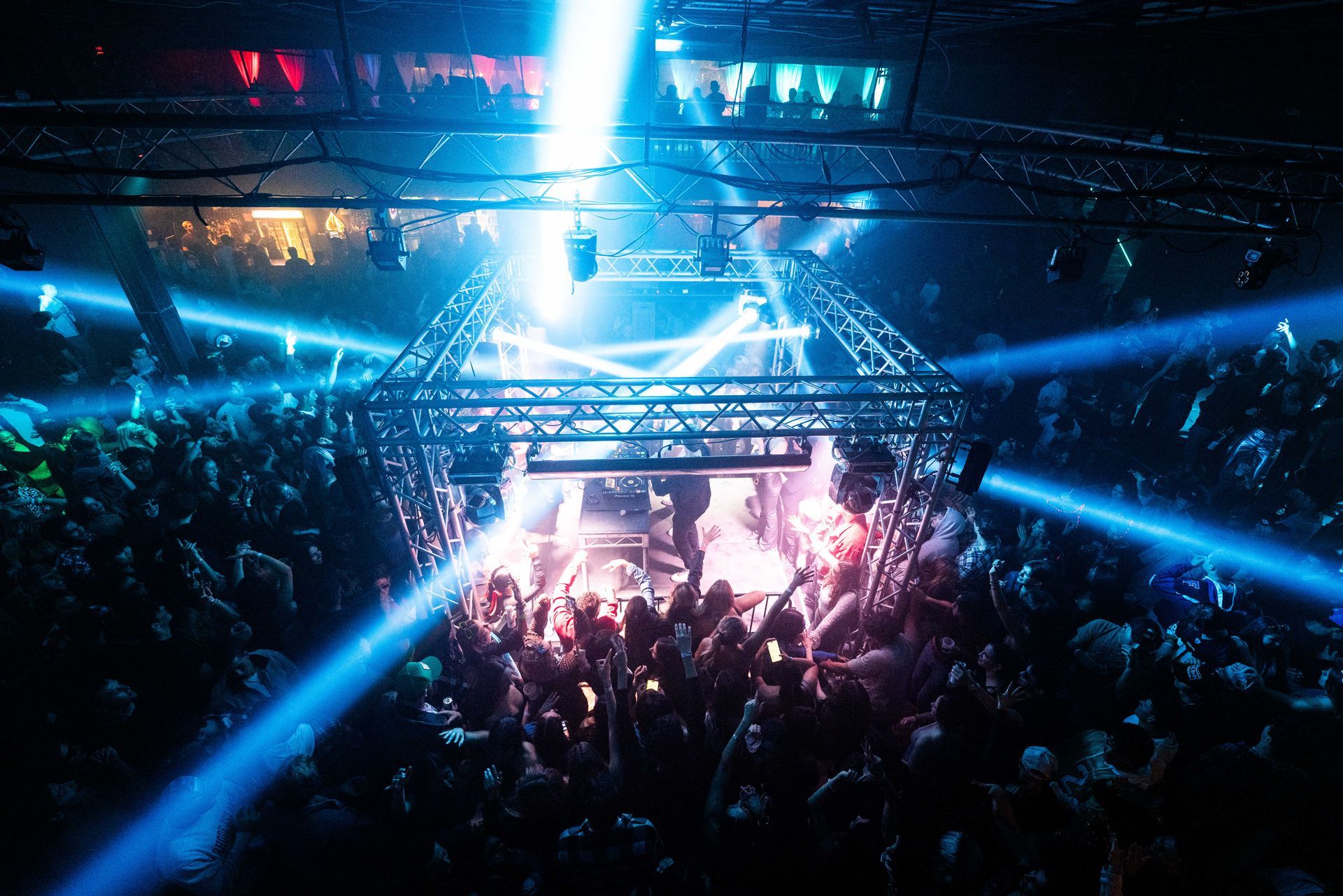 A crowd of people are watching a concert in a dark room