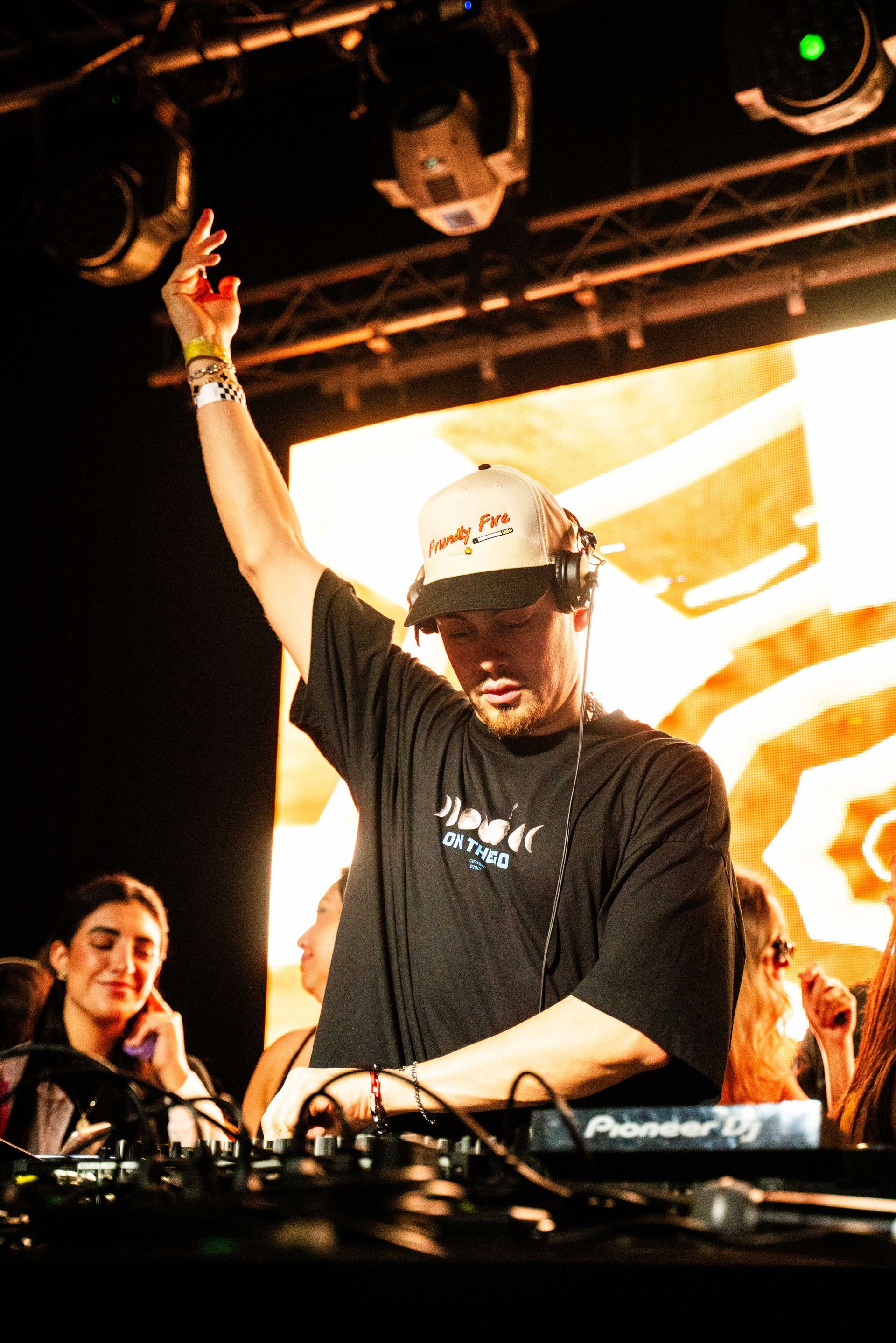 A man wearing a hat and headphones is playing music