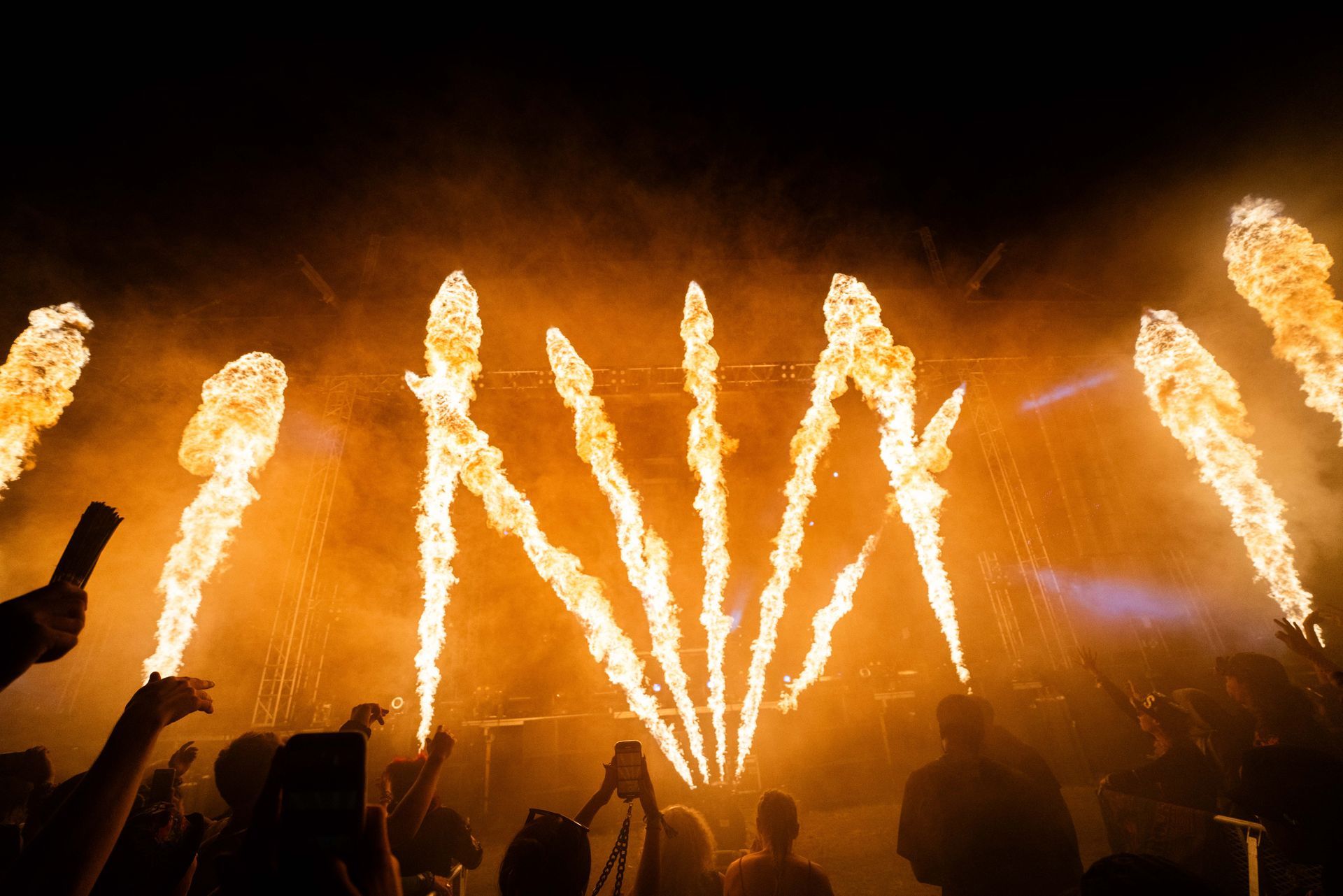 A crowd of people are watching fireworks at a concert.