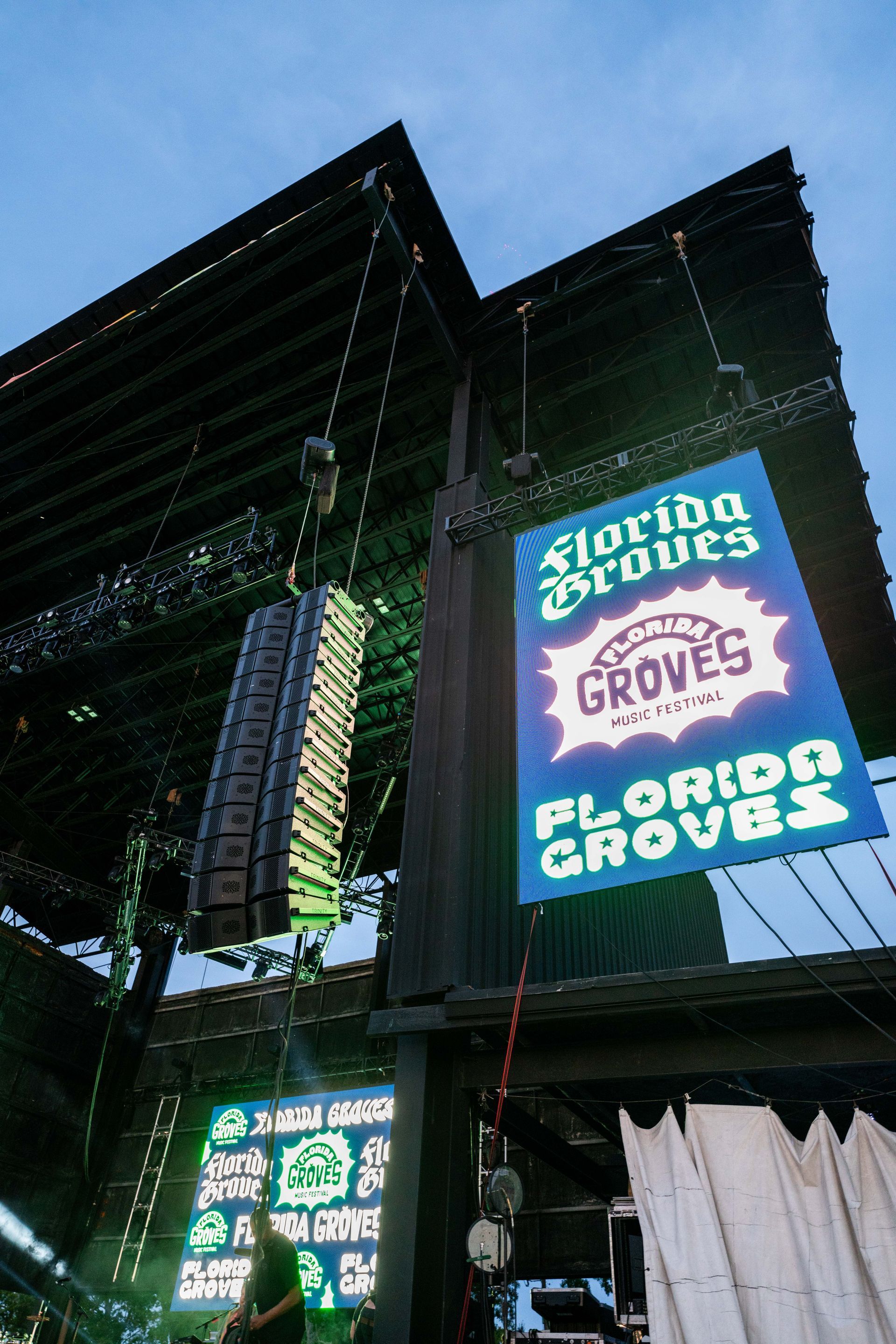 A florida braves sign is hanging from the roof of a stadium.