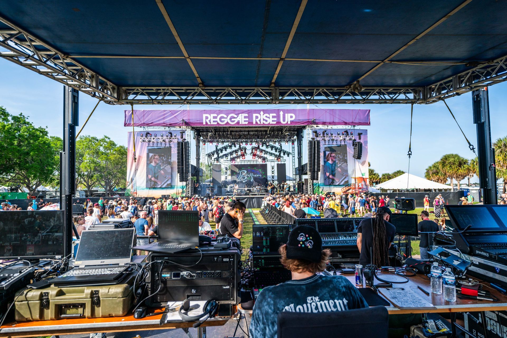 A man is sitting at a desk in front of a stage at a concert.