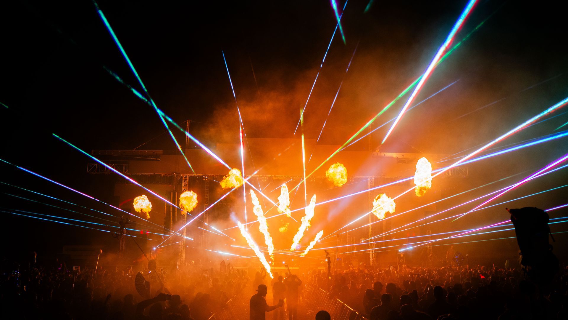 A crowd of people are watching a fireworks display at a concert.