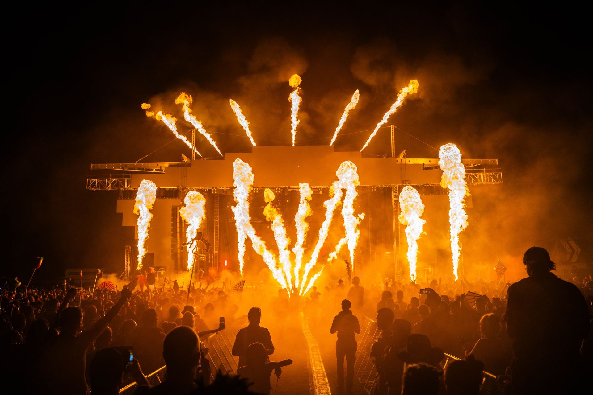 A crowd of people are watching fireworks at a concert.