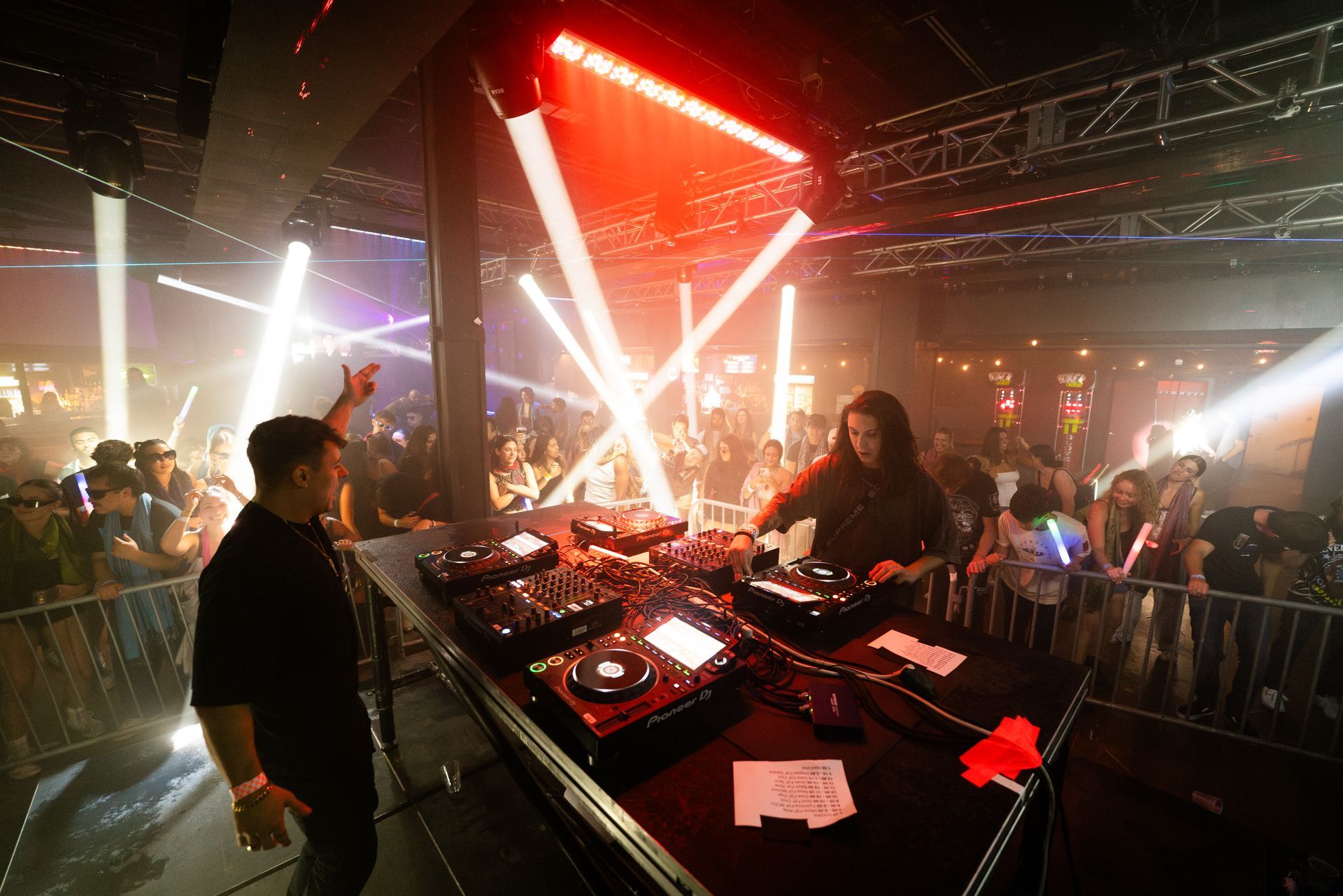A man and a woman are playing music at a party in a club.