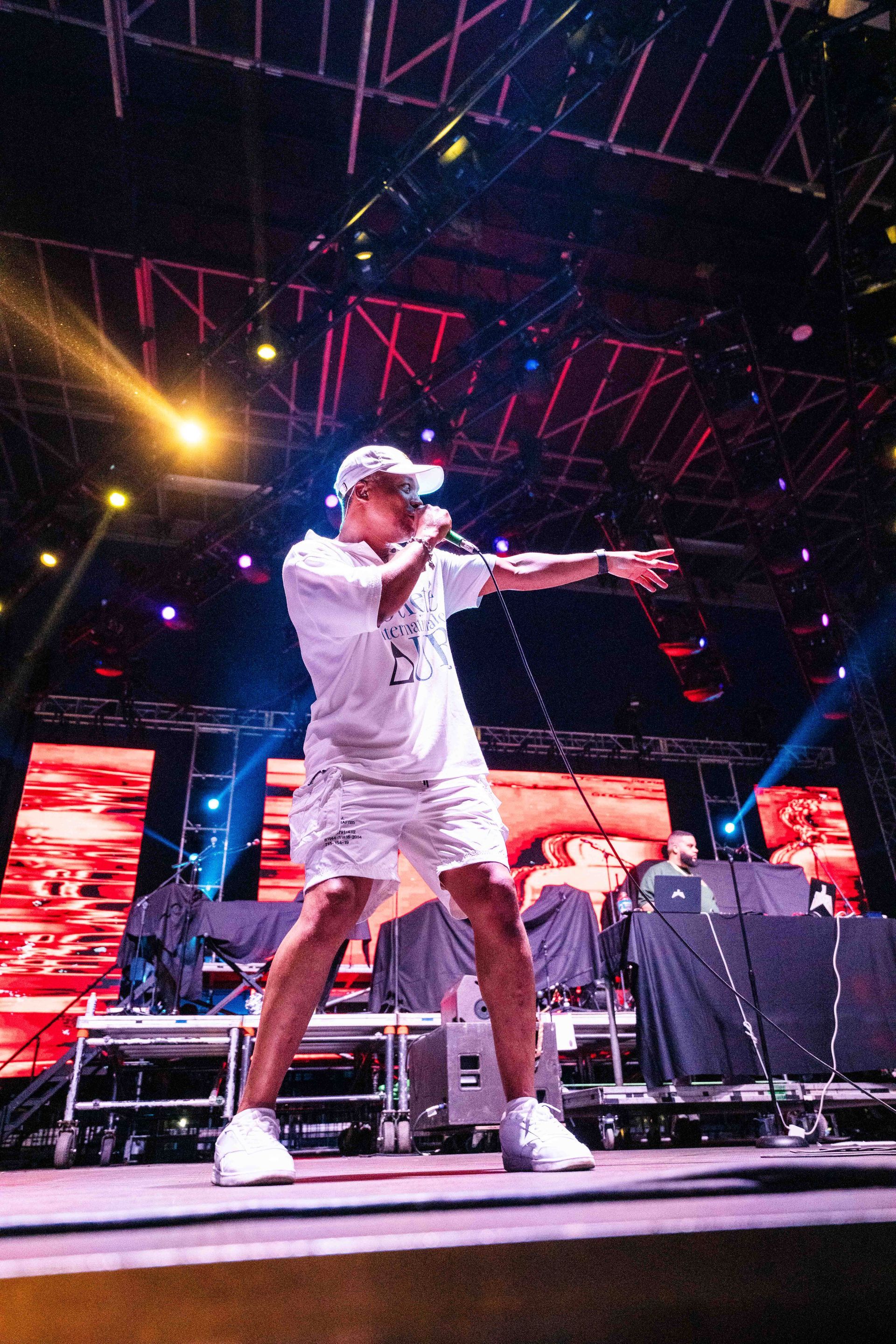 A man is standing on a stage holding a microphone.