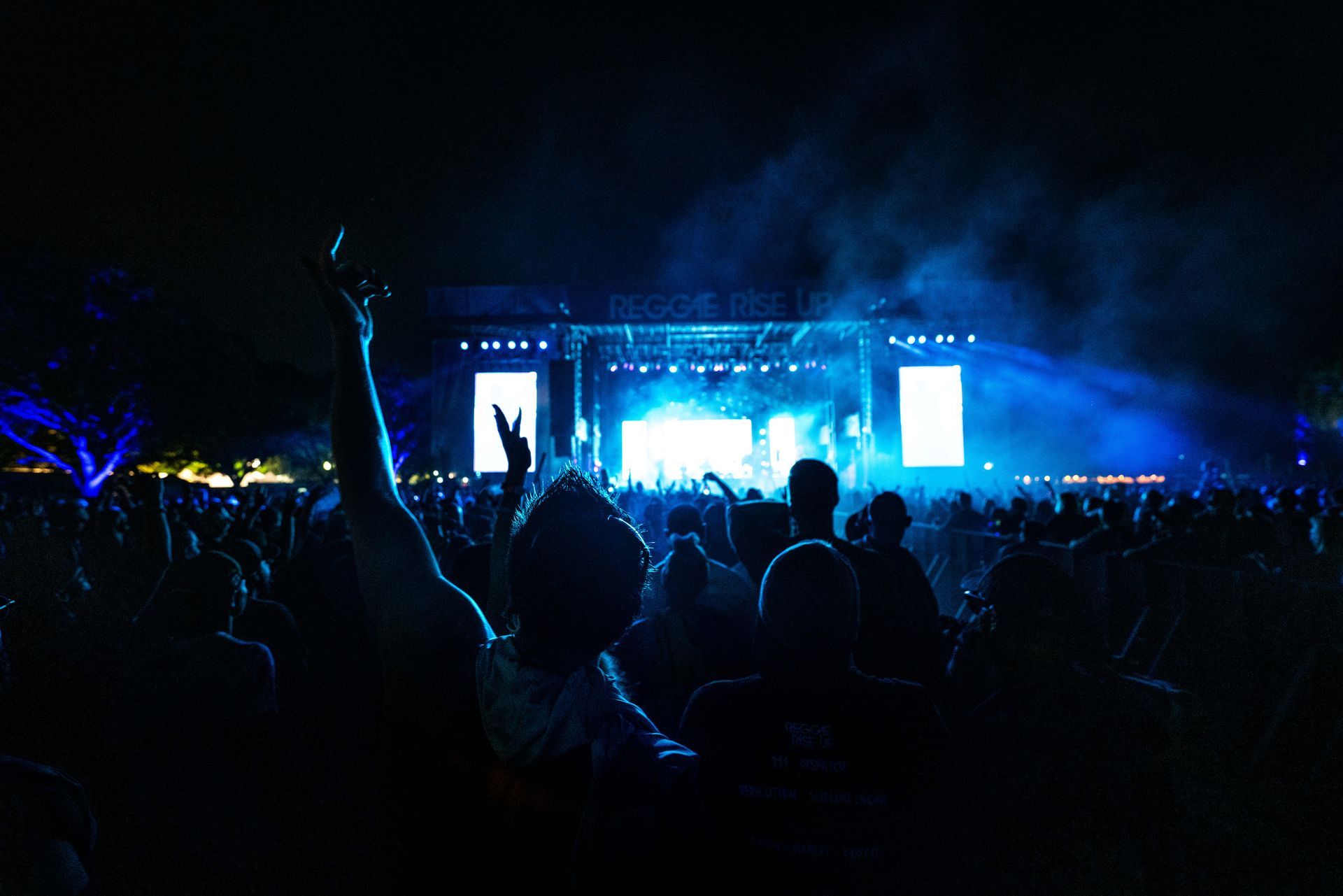 A crowd of people are standing in front of a stage at a concert.