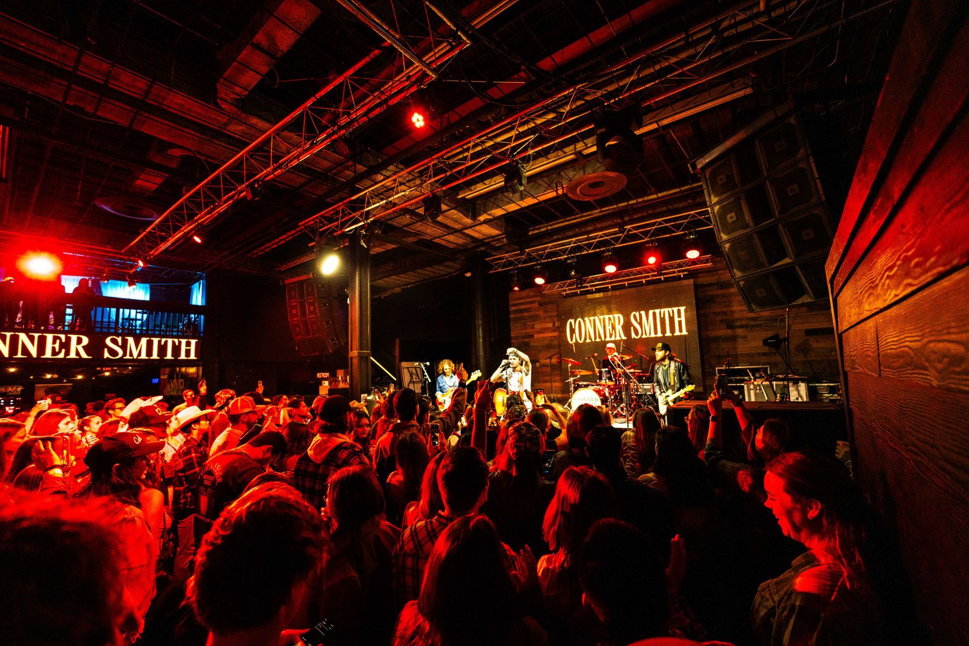 A crowd of people at a concert with a sign that says ' smith ' on it